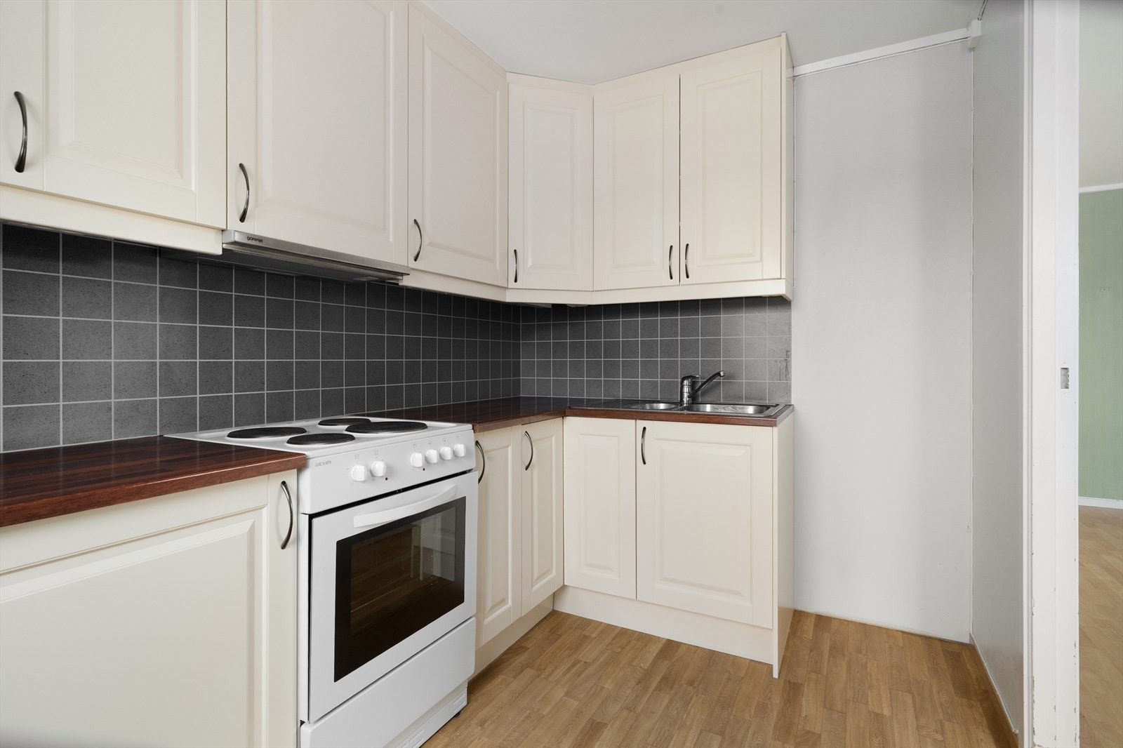 Innredningen består av over- og underskap som gir god oppbevaringsplass. Det er avsatt plass til frittstående hvitevarer som komfyr og kjøleskap Galleribilde