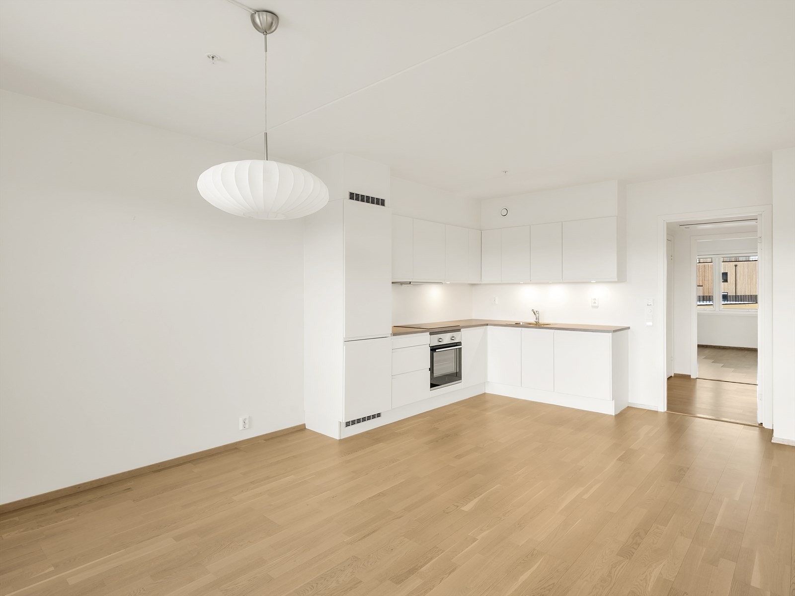 Den åpne løsningen mellom stue og kjøkken skaper en sosial sone med behagelig vannbåren gulvvarme. Galleribilde