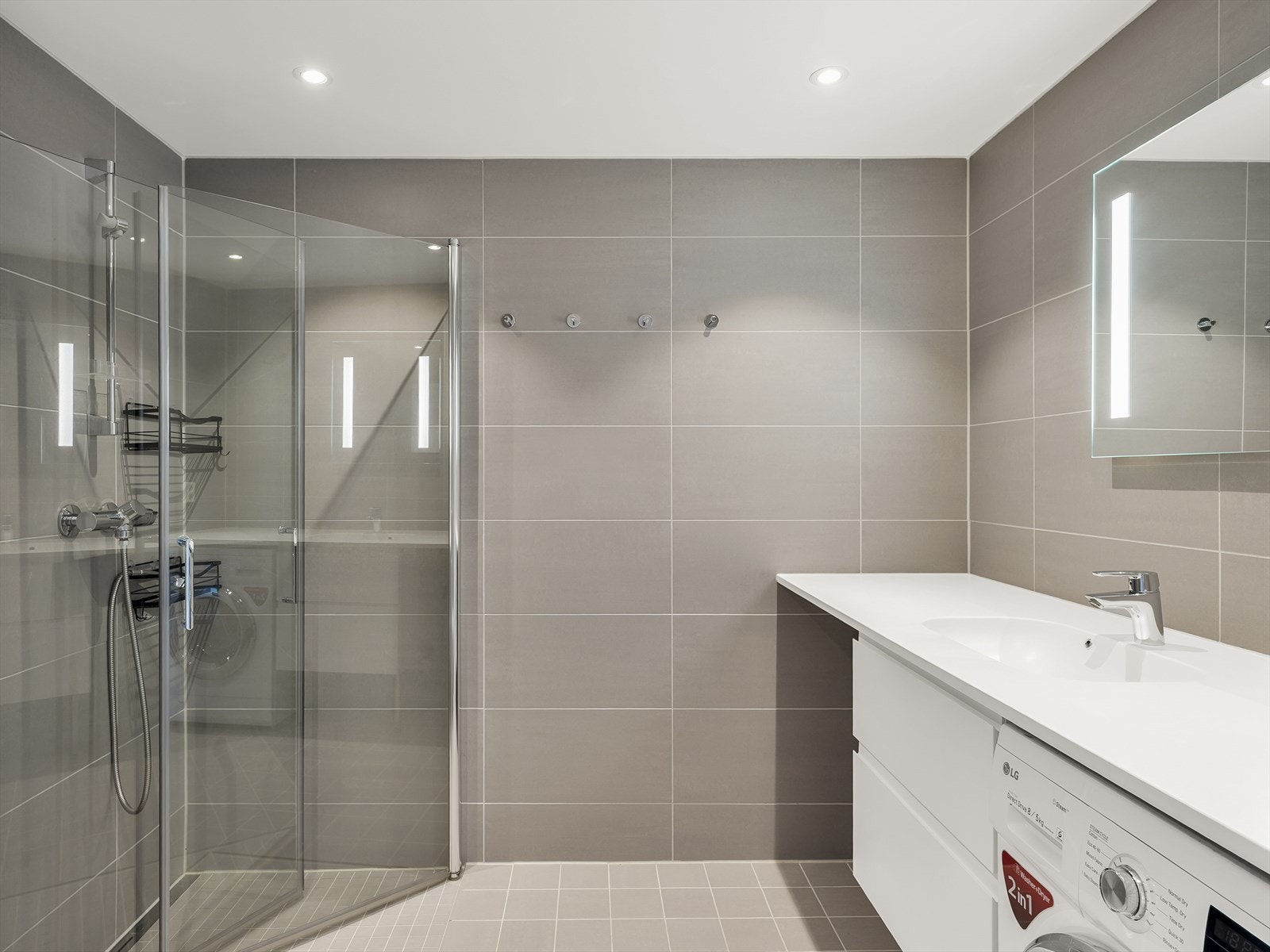 Moderne, flislagt bad med gulvvarme, downlights og en praktisk dusjløsning med glassvegger. Galleribilde