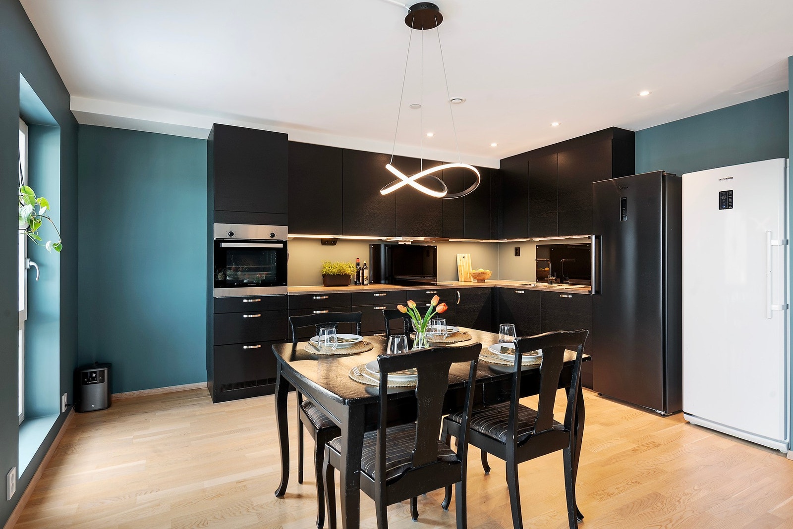 Moderne kjøkkeninnredning med mye oppbevaringsplass i over- og underskap Galleribilde