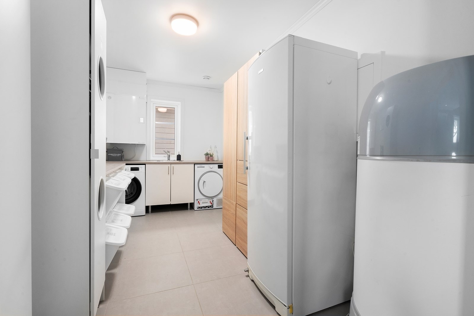 Praktisk vaskerom med god plass til oppbevaring, klessortering samt vaskemaskin og tørketrommel. Galleribilde