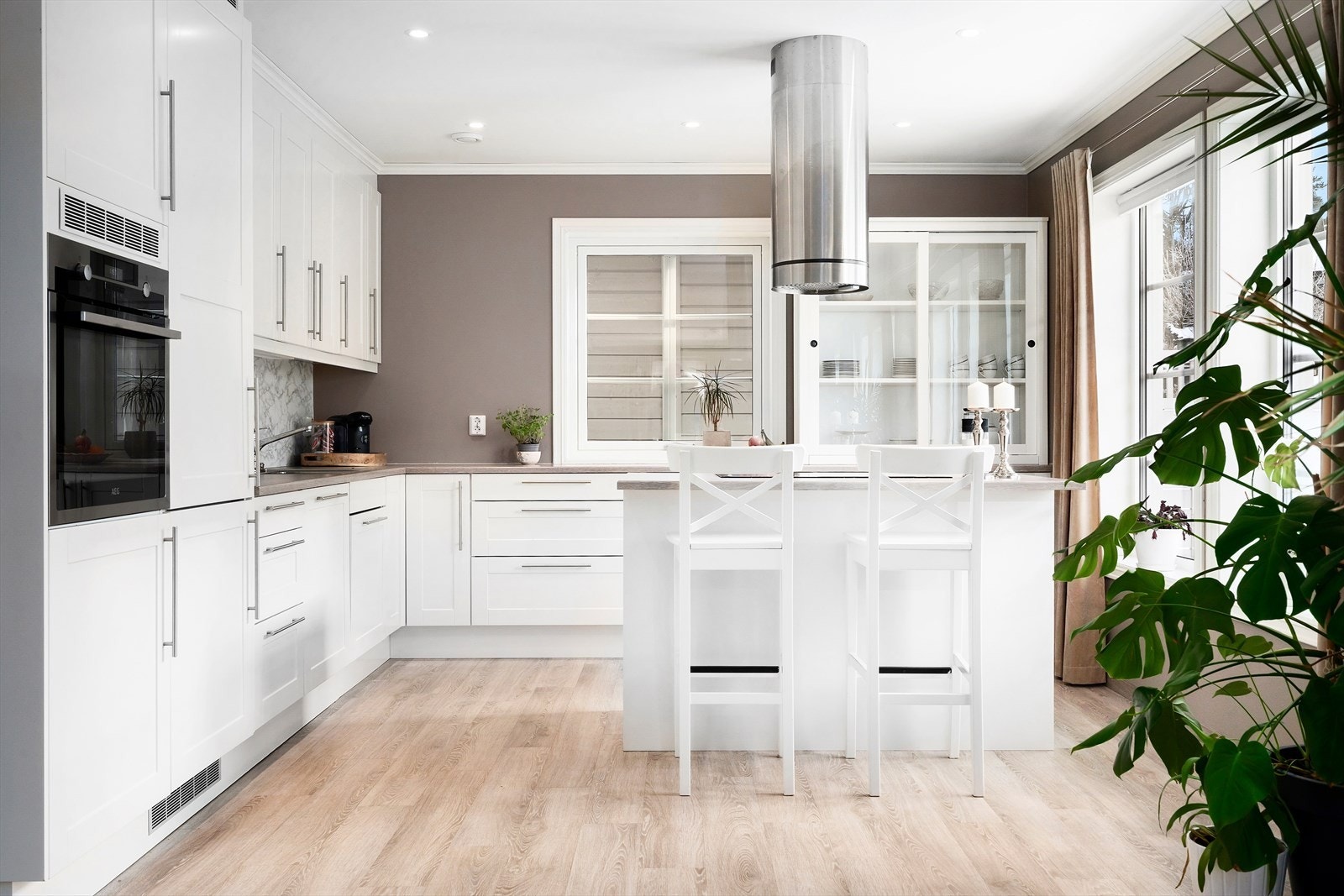 Pent kjøkken med profilerte fronter og laminat benkeplate. Galleribilde