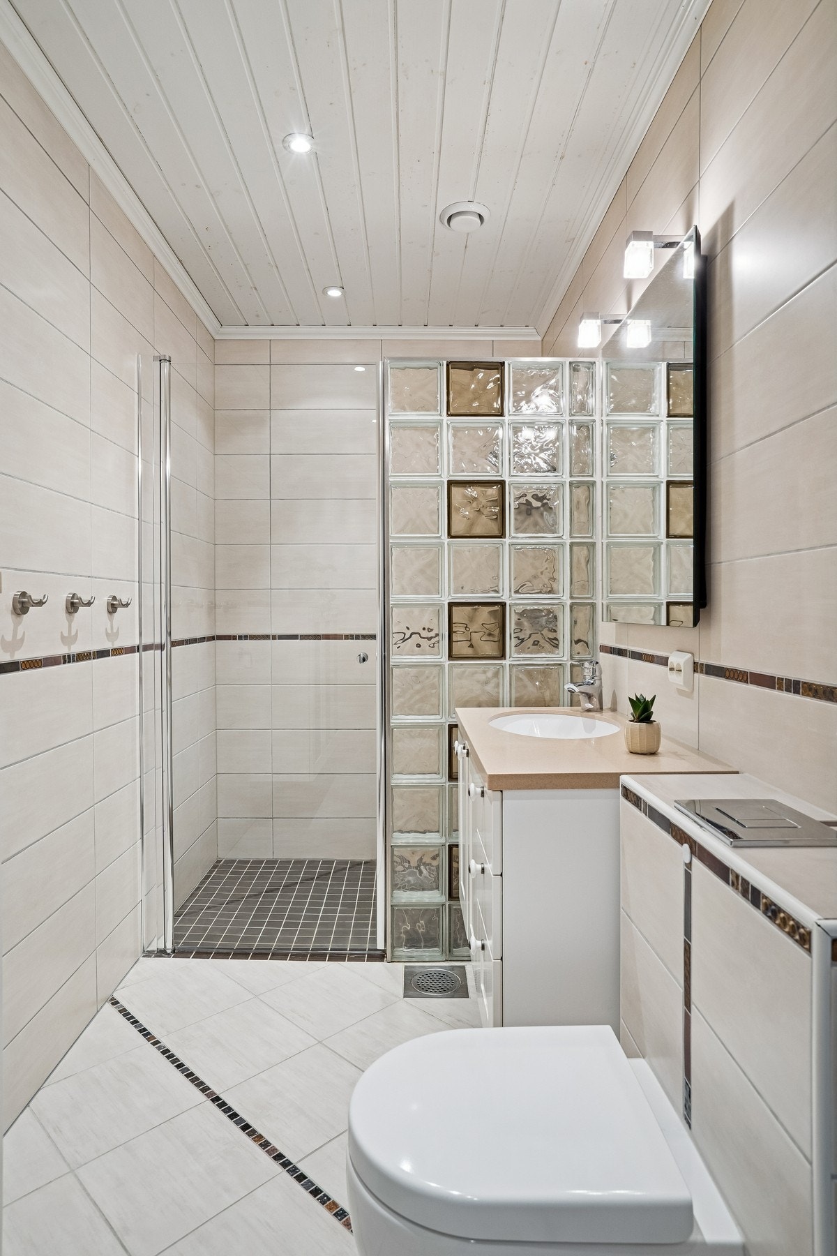 Bad i lyse og delikate farger med moderne innredning og romslig dusjnisje. Galleribilde