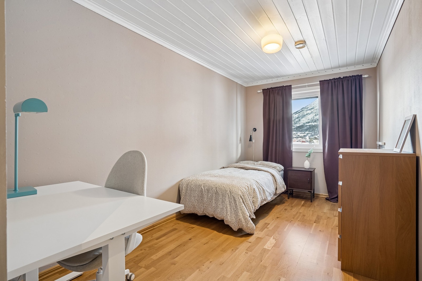 Ett av rommene har direkte utgang til terrasse og plen. Galleribilde