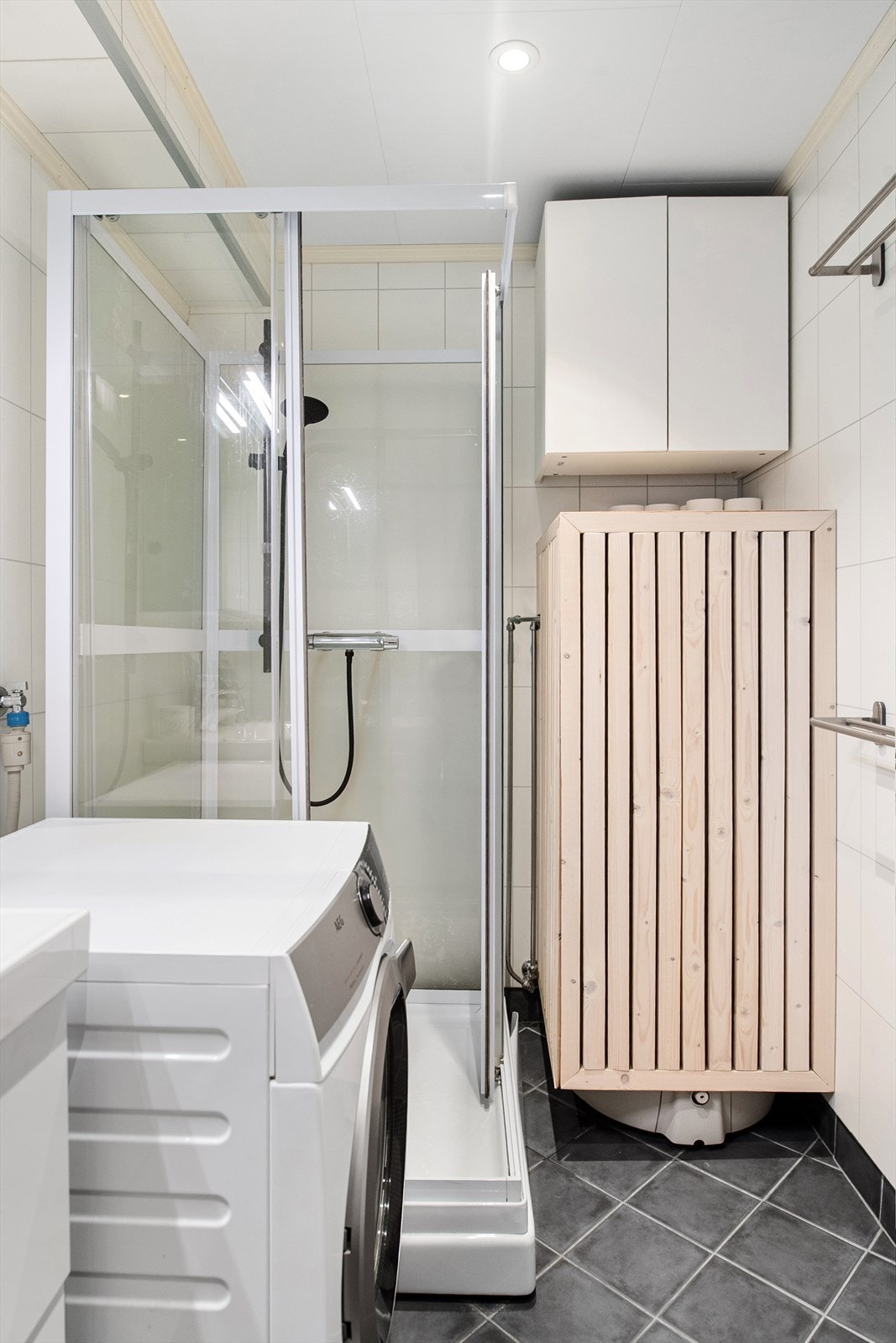 Badet har dusjkabinett og opplegg for vaskemaskin. Varmtvannstanken er også plassert i rommet. Galleribilde