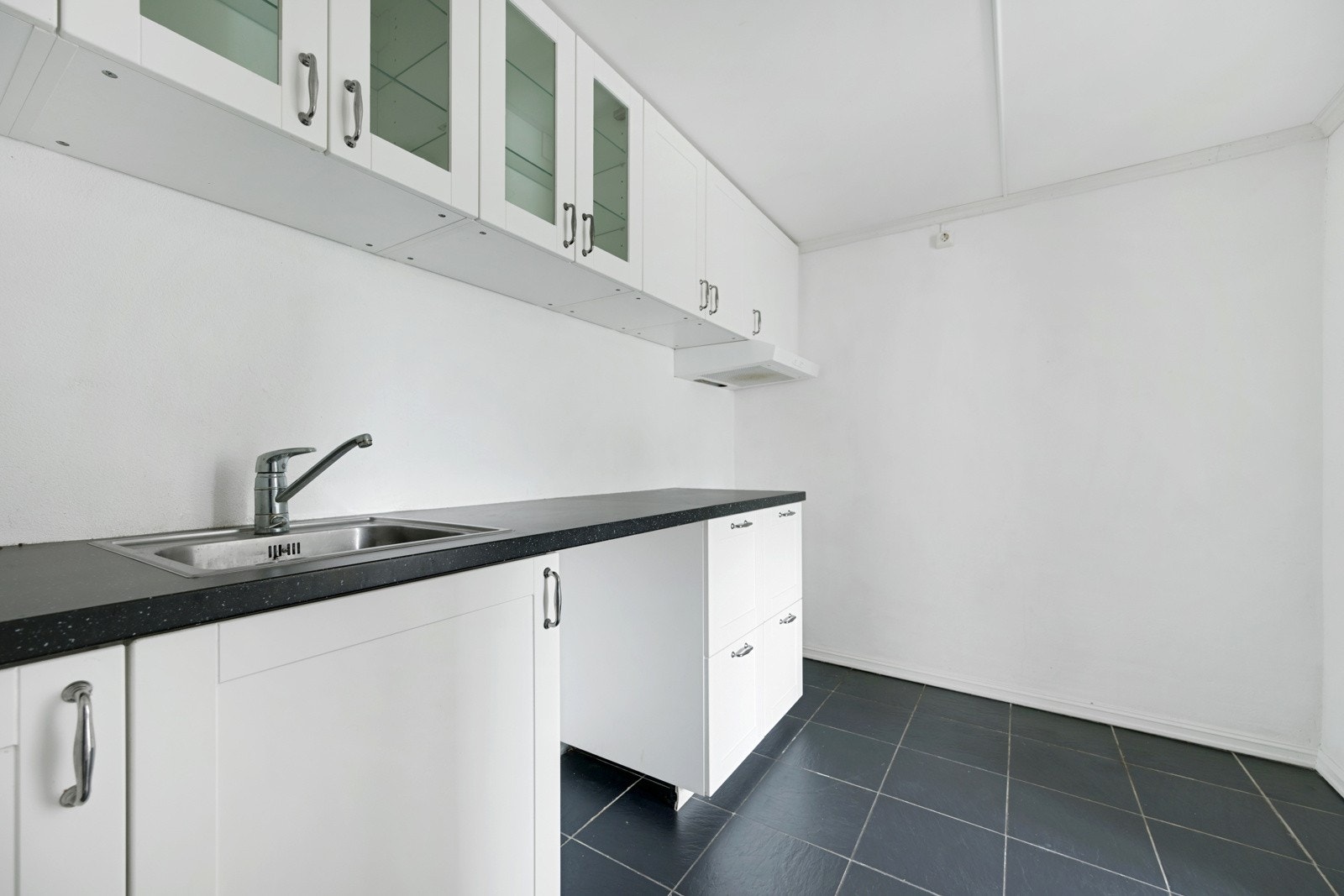 Kjøkken med en fin lys innredning, benkeplate og oppvaskkum Galleribilde