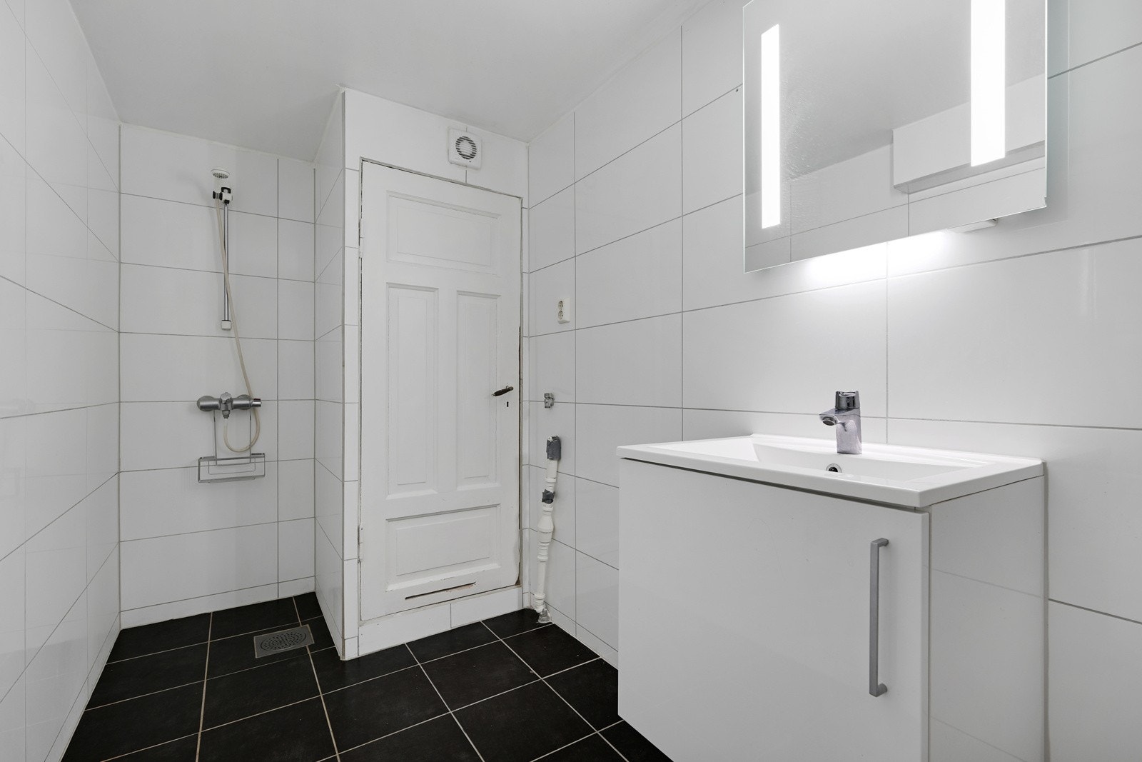 Flislagt bad i utleiedelen med servant, wc og dusjhjørne. Galleribilde