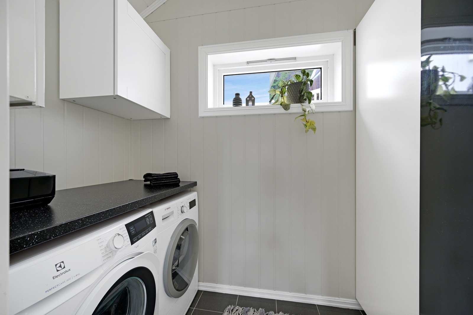 Vaskerom med opplegg for vaskemaskin, noe som er praktisk for enhver Galleribilde