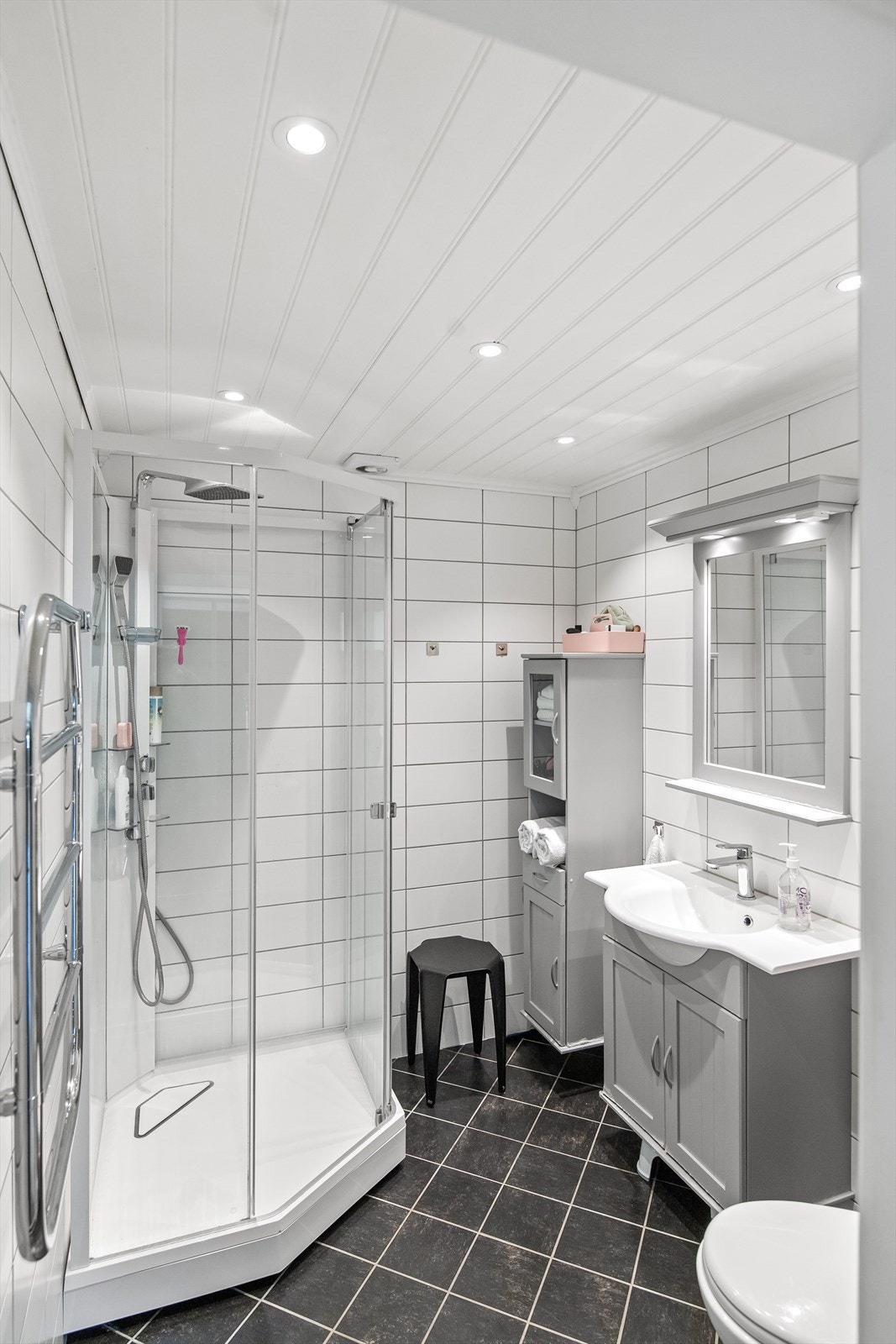 Det fremstår er lyst og delikat med servant i baderomsinnredning, dusjkabinett og vegghengt toalett. Galleribilde