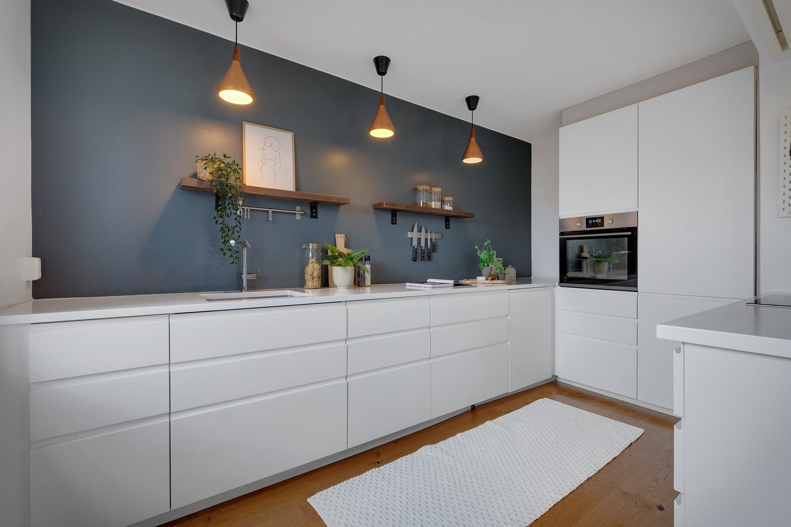 Lekkert nyere kjøkken av slette hvite fronter med integrerte håndtak Galleribilde