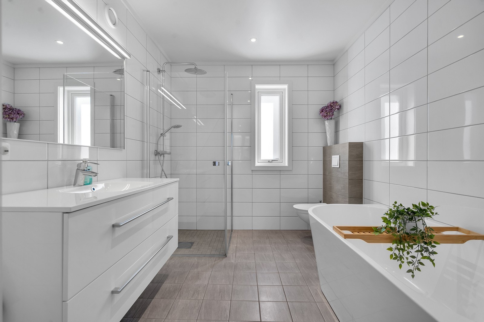 Flislagt bad med både dusjhjørne og badekar Galleribilde