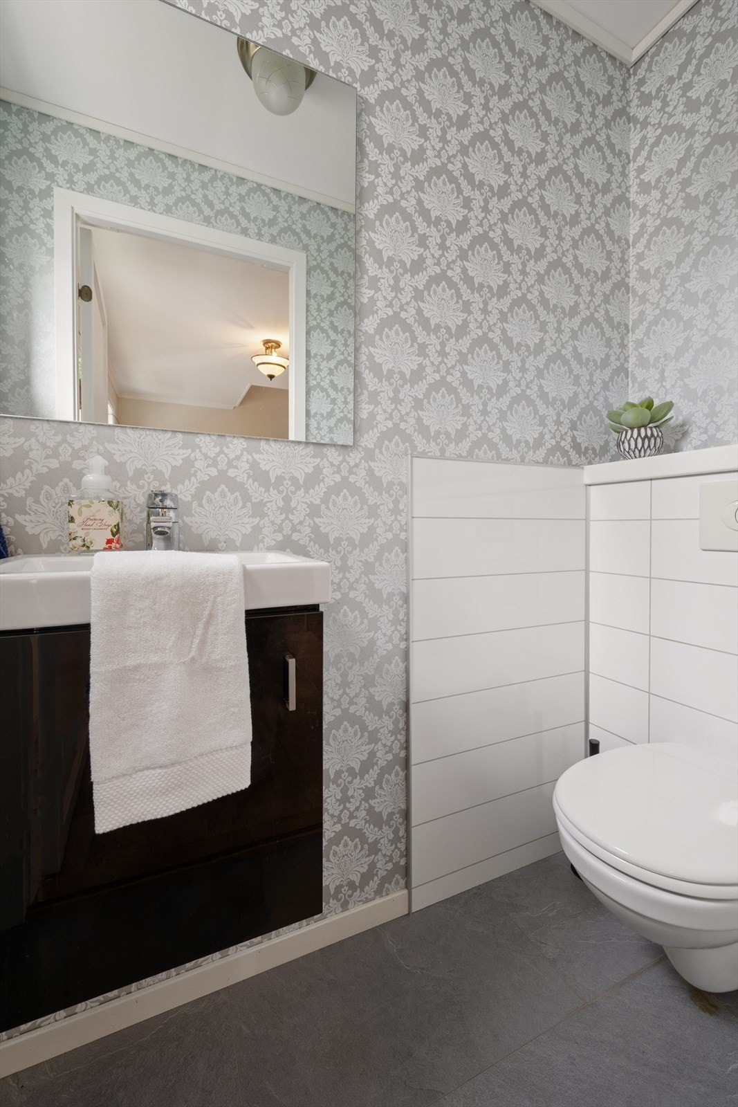 I tilknytning til entreen finner man et gjestetoalett som er utstyrt med vegghengt toalett og baderomsinnredning med servant. Galleribilde