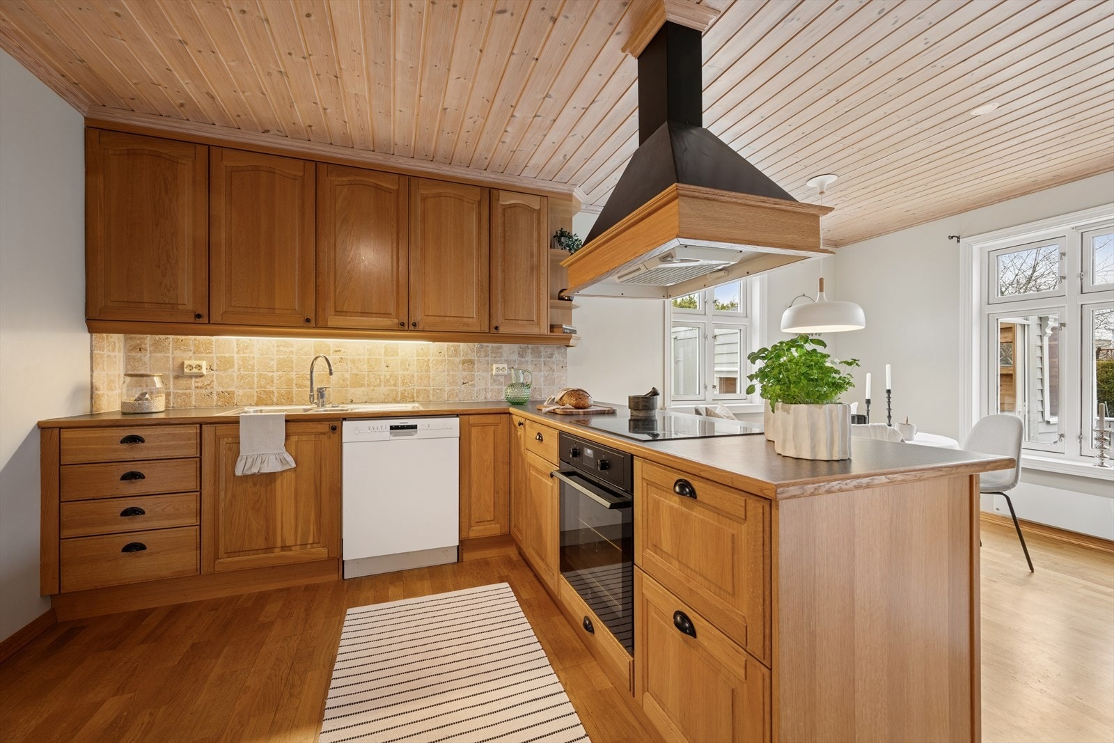 Kjøkkenet er innredet med profilerte eikefronter og grå benkeplate av laminat med eikekant. Et stort og godt kjøkken hvor man har godt med skap- og skuffeplass, samt gode arbeidsflater på benk. Galleribilde