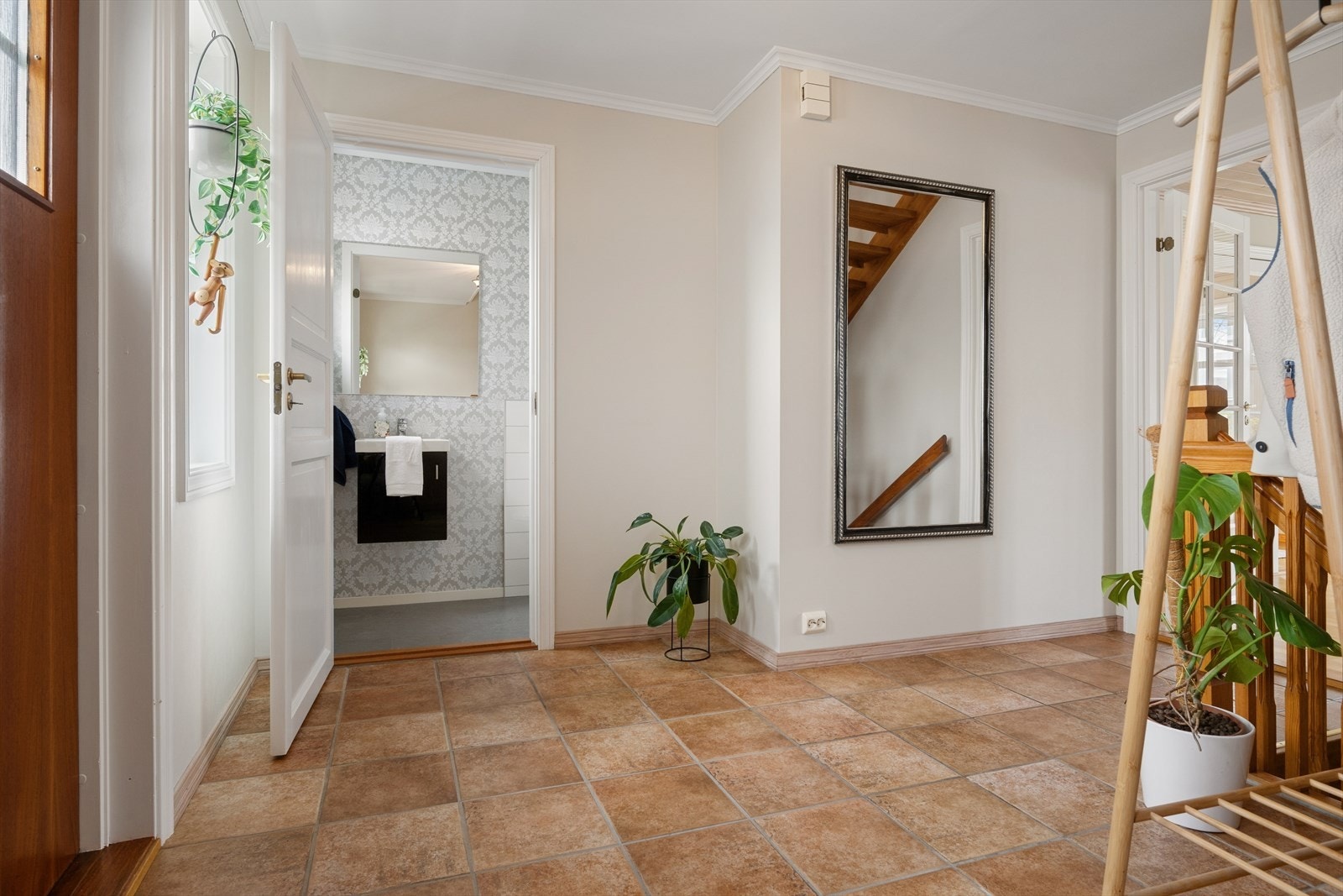 Man ønskes velkommen inn i en romslig og praktisk innredet entré med flislagt gulv. Galleribilde