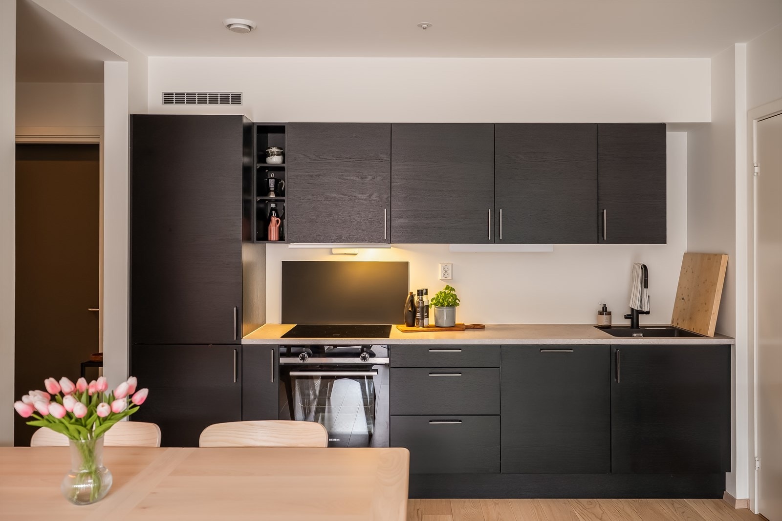 Delikat kjøkken fra HTH med Siemens hvitevarer med tilvalg av sorte kjøkkenfronter. Galleribilde