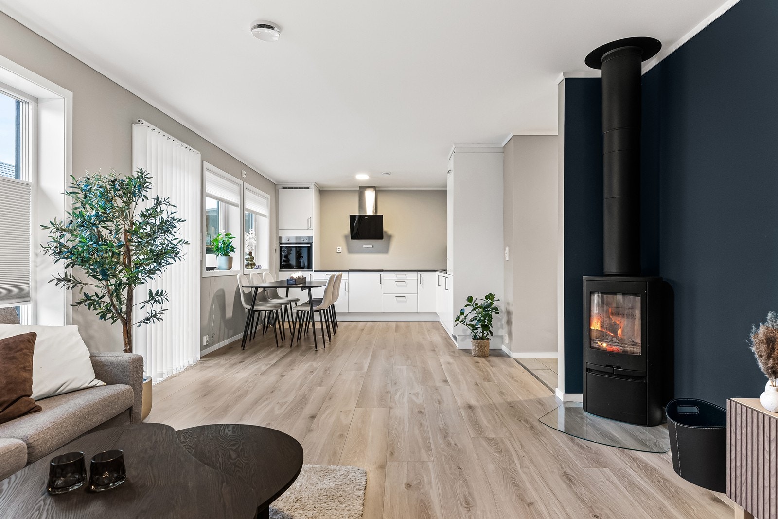 Stue med enstavs laminatgulv og malte gipsvegger. Stålpipe med vedovn type Contura Galleribilde