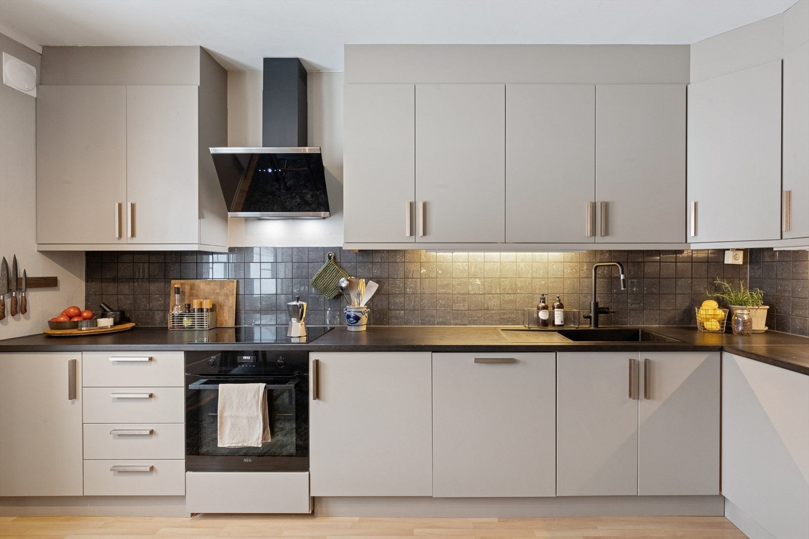 Kjøkkeninnredningen har slette fronter og moderne løsninger, inkludert integrert stekeovn. Frontene ble malt opp og man byttet knotter for kort tid tilbake. Galleribilde