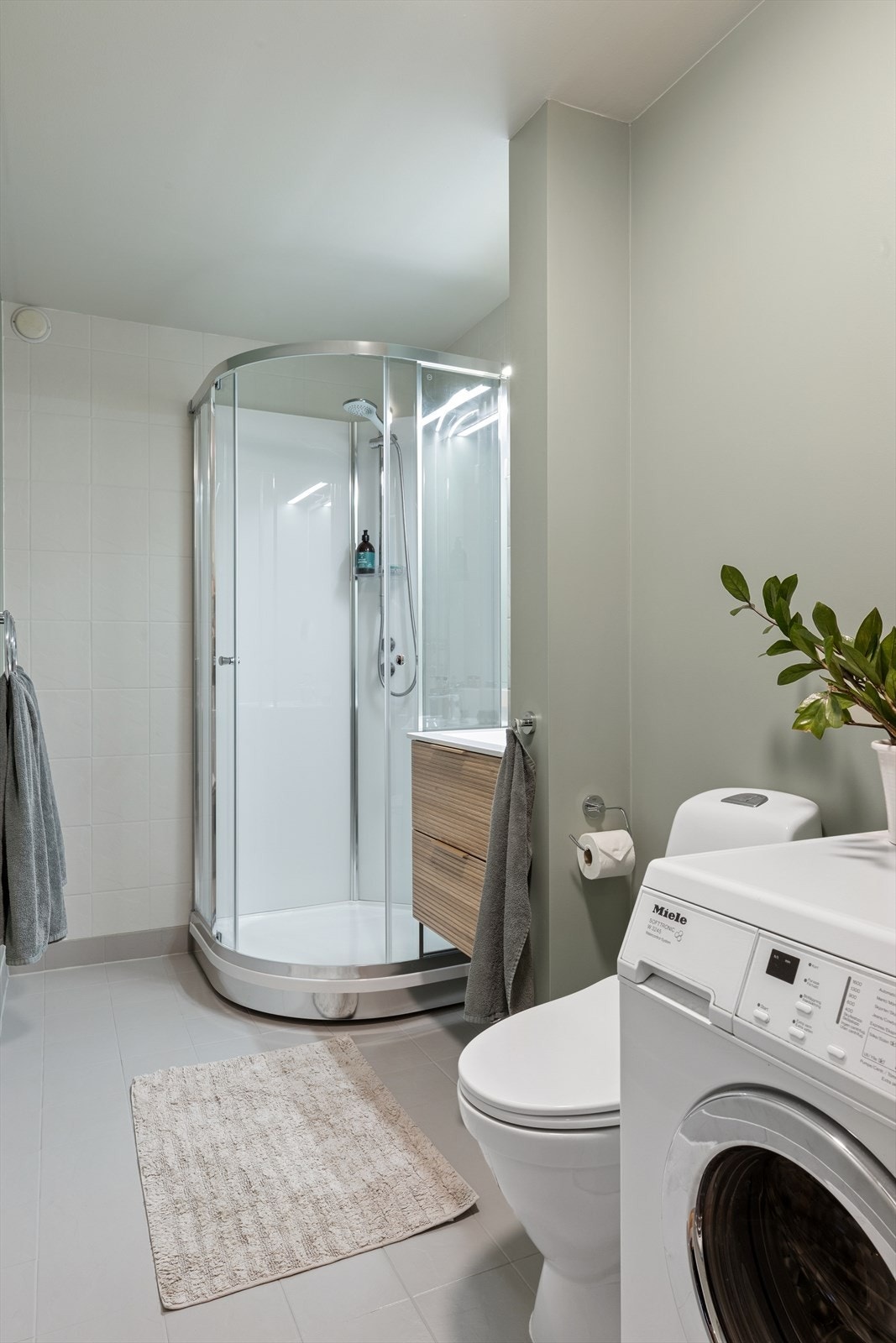 Badet er funksjonelt innredet med dusjkabinett og opplegg for vaskemaskin. Badet er eldre, men fungere som det skal, men man må påregne oppgraderinger på sikt. Galleribilde