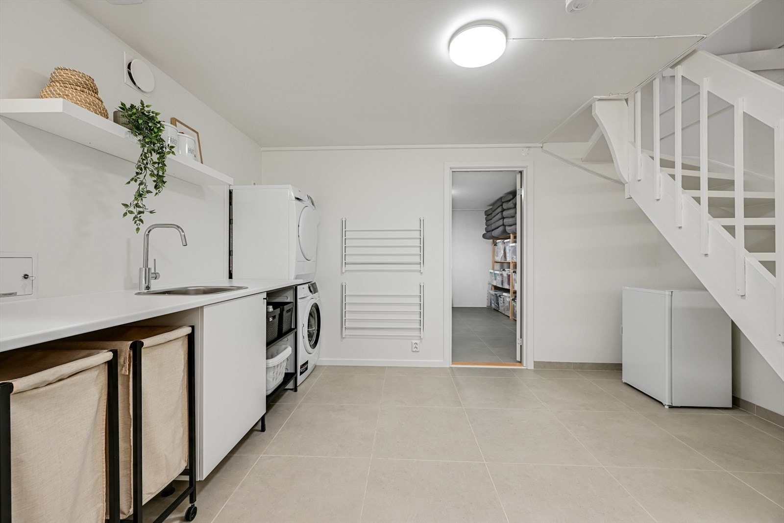 Romslig vaskerom i kjelleretasjen med direkte adkomst via trapp fra hovedetasjen. Opplegg for vaskemaskin og tørketrommel, utslagsvask og godt med arbeidsbenk. Galleribilde