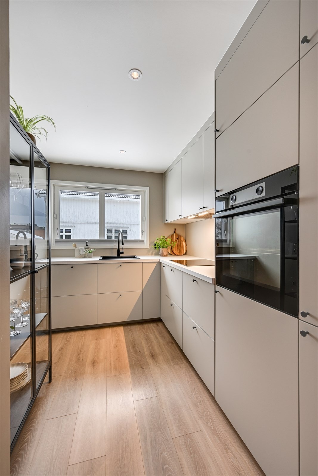 Stilrent kjøkken med slette fronter, laminerte benkeplater, og integrerte hvitevarer. Galleribilde