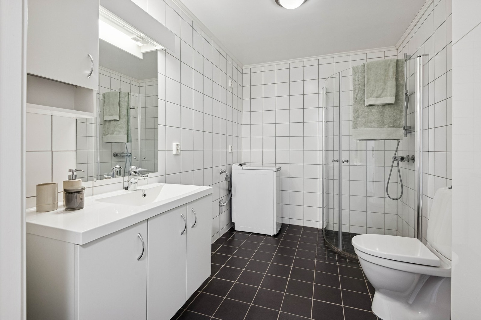 Pent flislagt bad med opplegg for vaskemaskin. Galleribilde