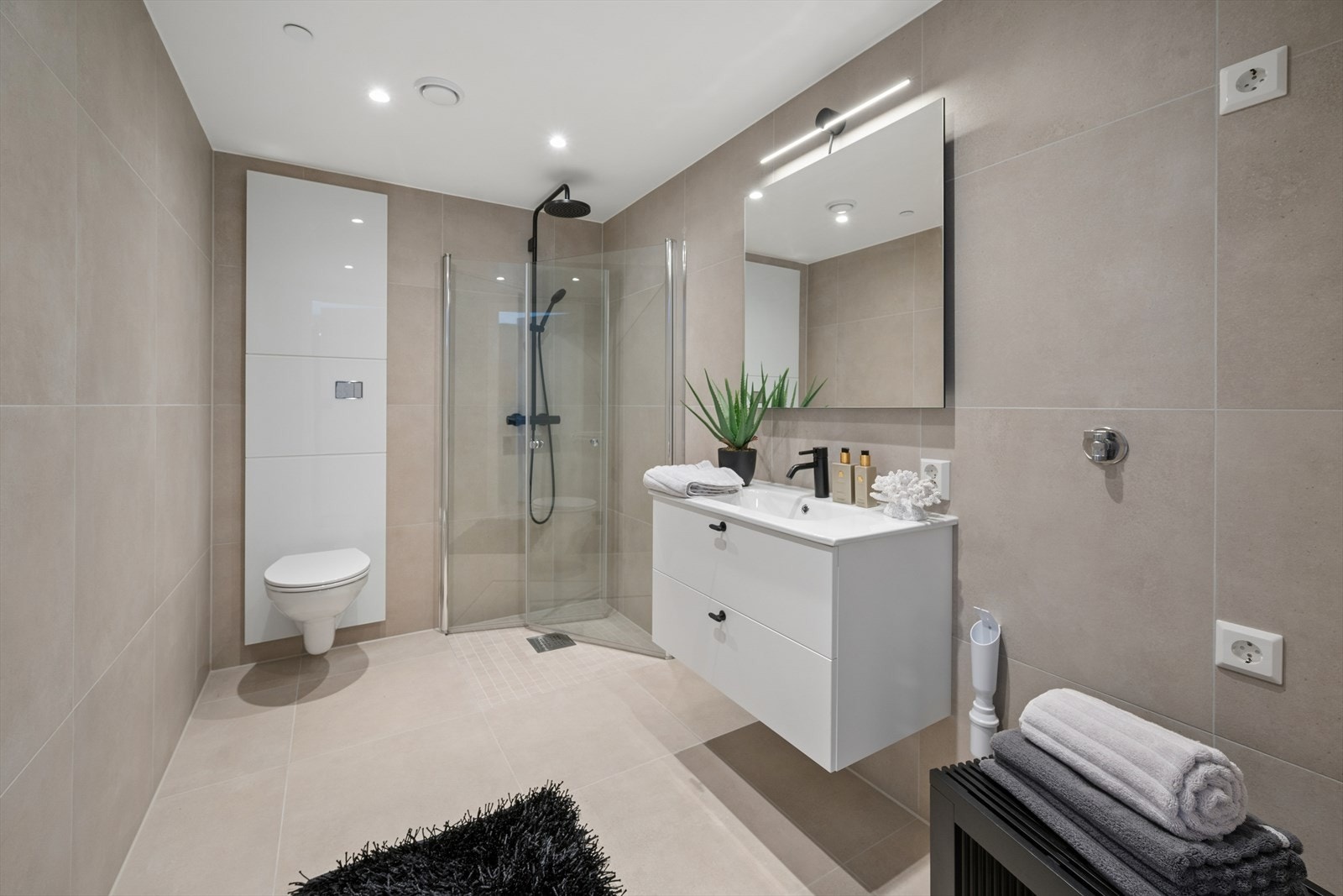 Baderom fra soverom er romslig og pent. Flakestone 60x60 fliser i light greige matt utførelse. Galleribilde