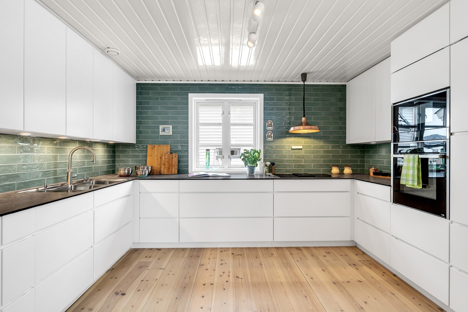 Praktisk kjøkkenløsning med integrerte hvitevarer og kompaktlaminat benkeplate. Galleribilde