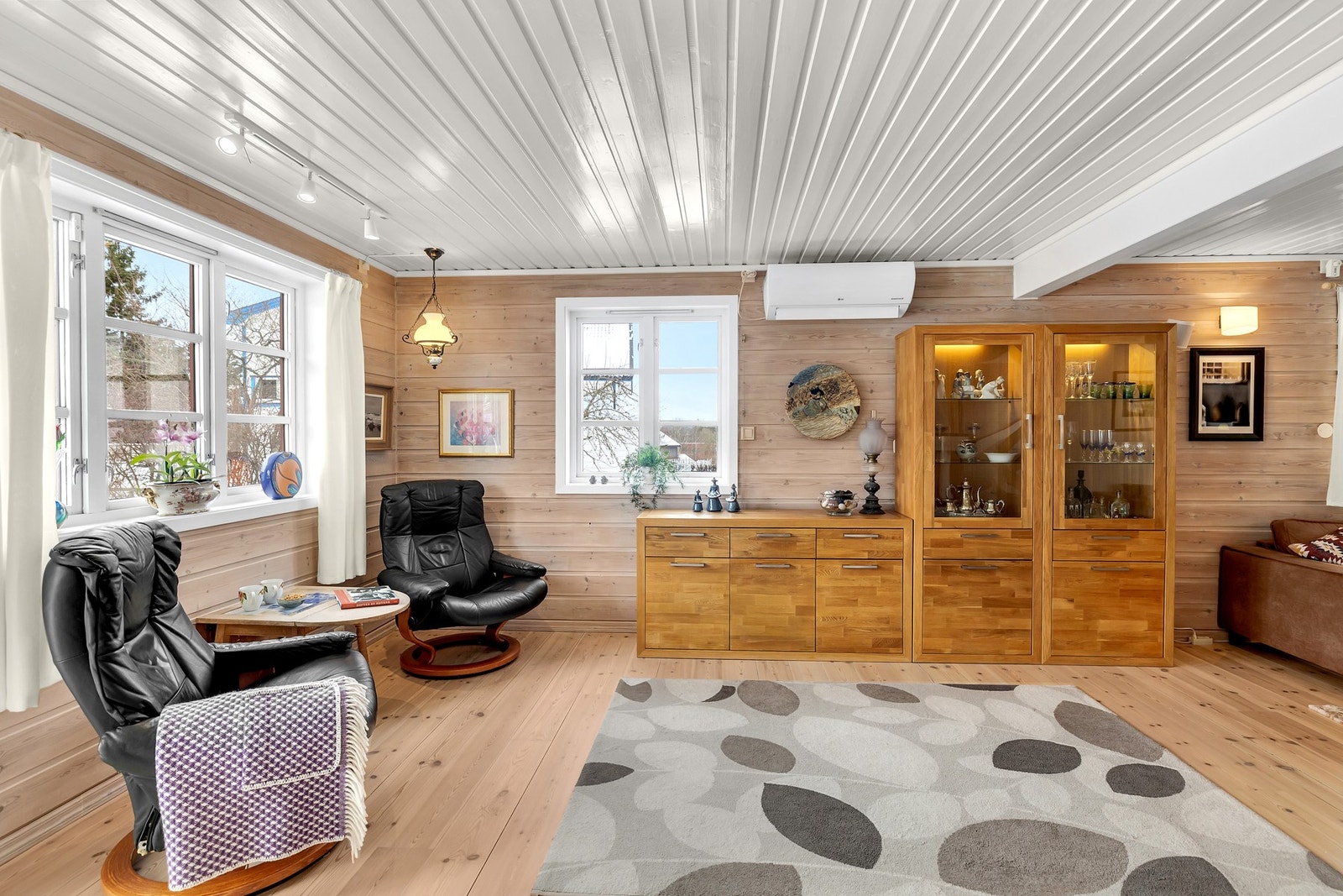 Boligens stue er av god størrelse og byr på store vinduer som slipper inn rikelig med naturlig lys. Galleribilde