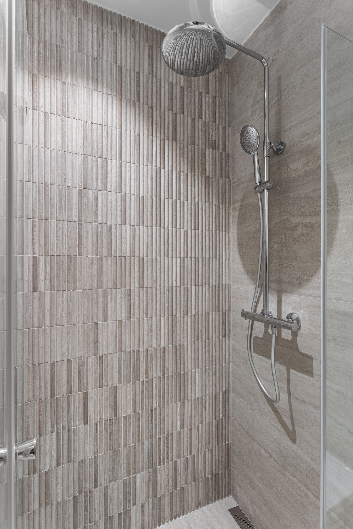 Designmessige fliser i dusjen. Luksus med både waterfall- og hånddusj. Galleribilde