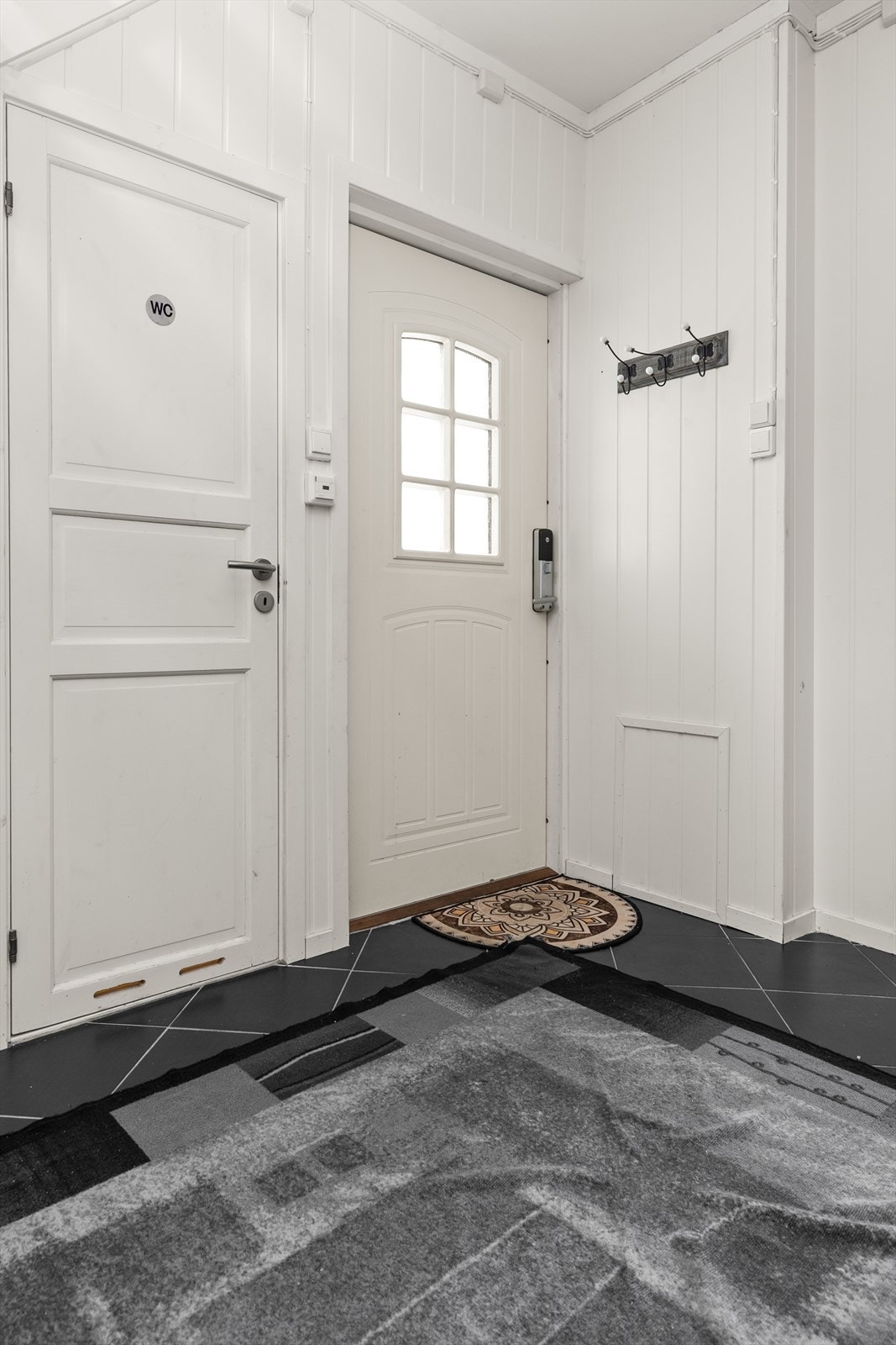 Entré med flislagt gulv og direkte adkomst til gjestetoalett. Galleribilde