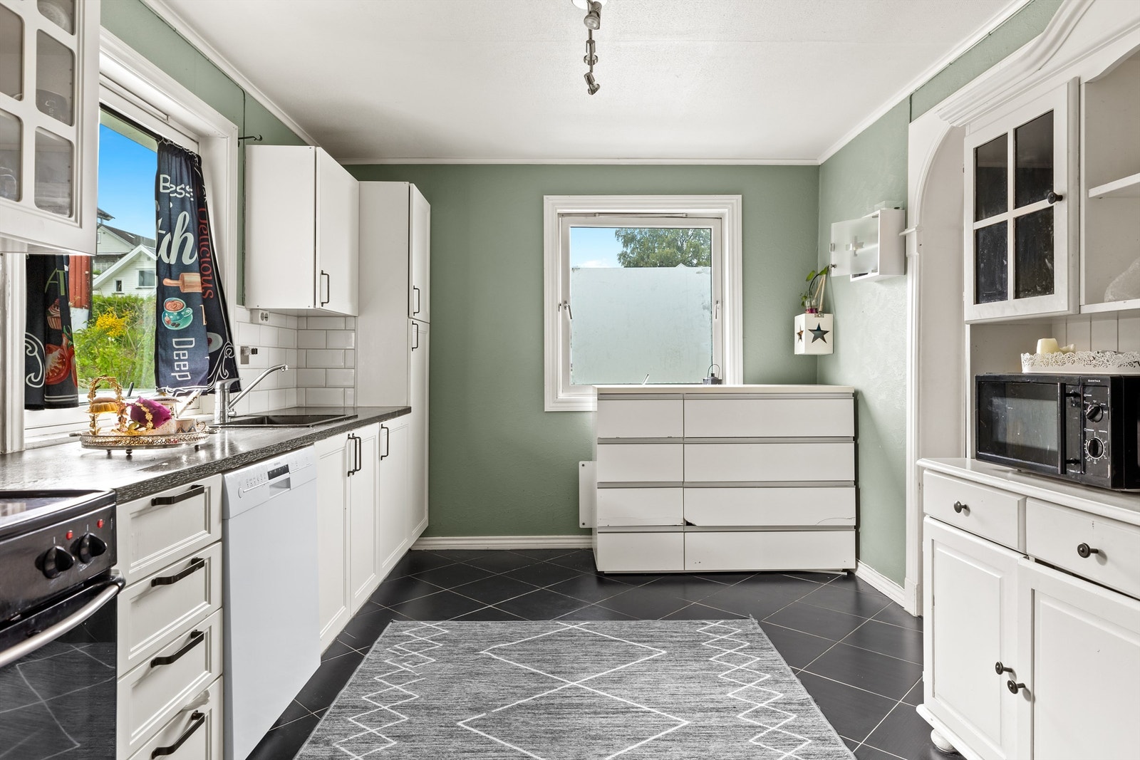 Funksjonelt kjøkken med lyse fronter, flislagt benkerygg og godt med skap- og benkeplass. Galleribilde