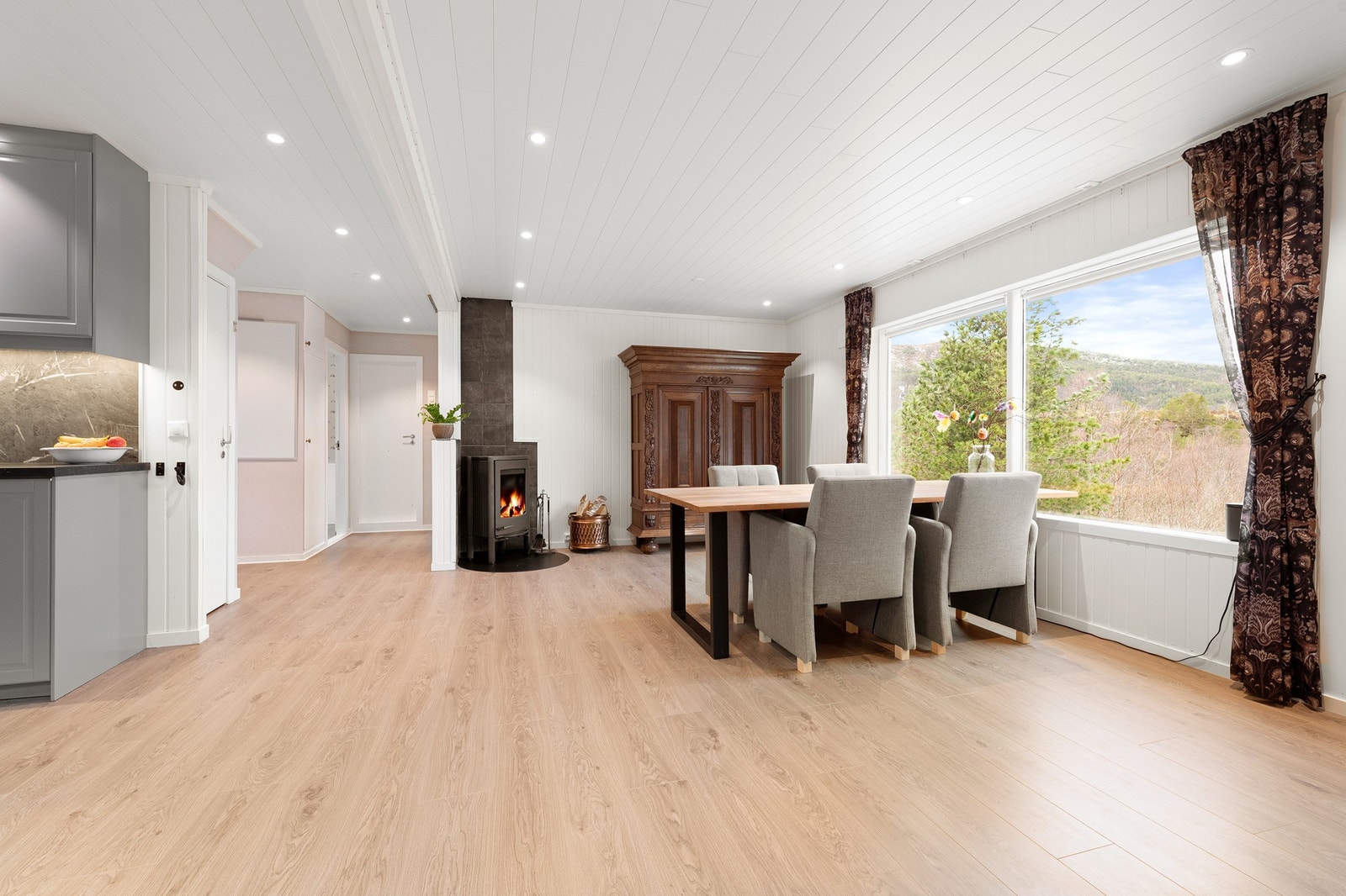 Åpen og romslig stue med spotter i tak og nyere laminatgulv Galleribilde