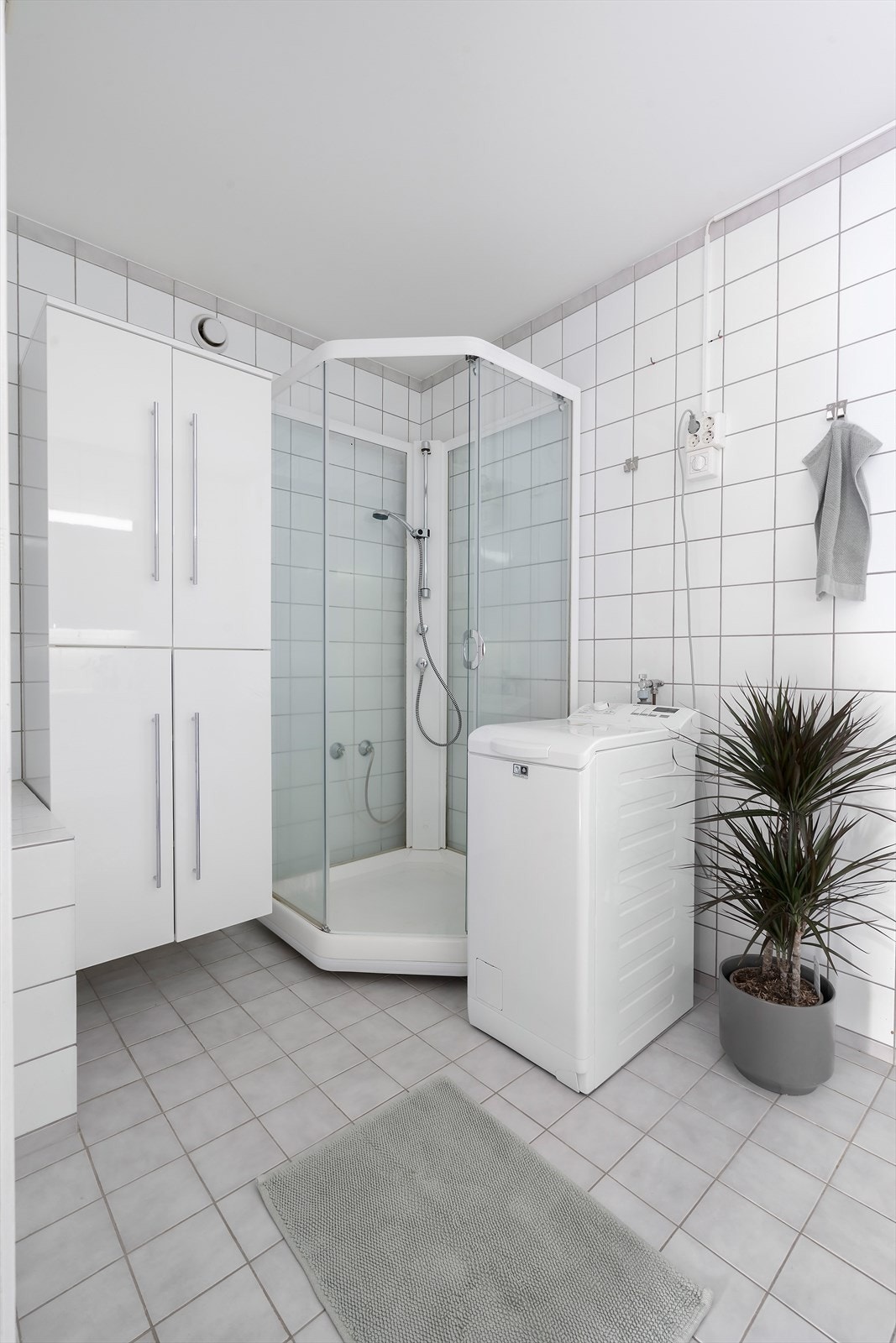 Rommet er utstyrt med nyere benkeskap med servant, toalett, dusjkabinett og opplegg for vaskemaskin. Galleribilde