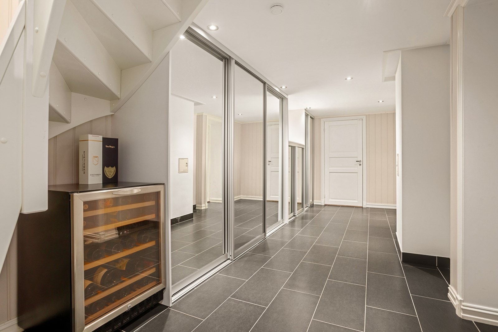 Romslig gang med flislagt gulv og varmekabler - praktisk skyvedørsgarderobe for ytterligere oppbevaringsmuligheter Galleribilde