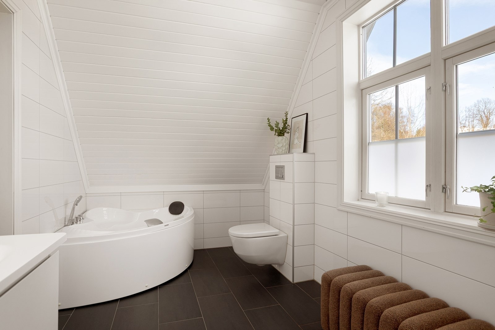 Badet er utstyrt med heldekkende servant med underskap, speilskap med lys, dusjkabinett, badekar og toalett Galleribilde