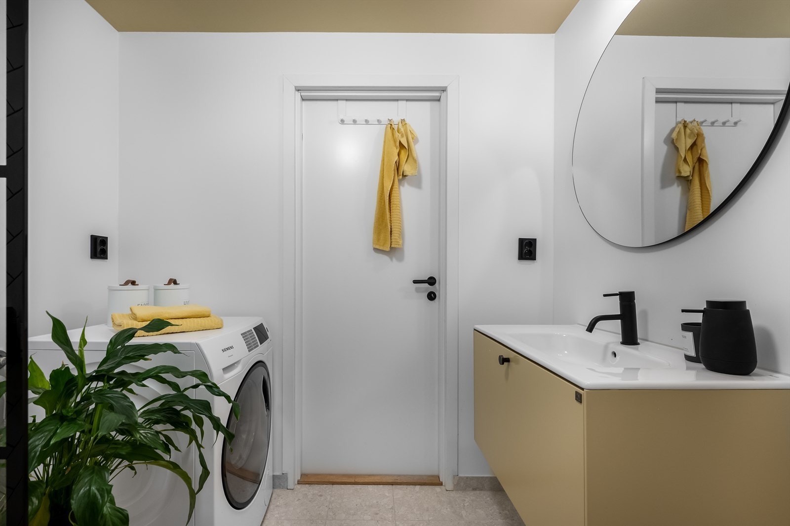 Badet har flislagte flater kombinert med malte vegger og innvendig malt himling, noe som gir et moderne og rent uttrykk. Opplegg for vaskemaskin. Galleribilde