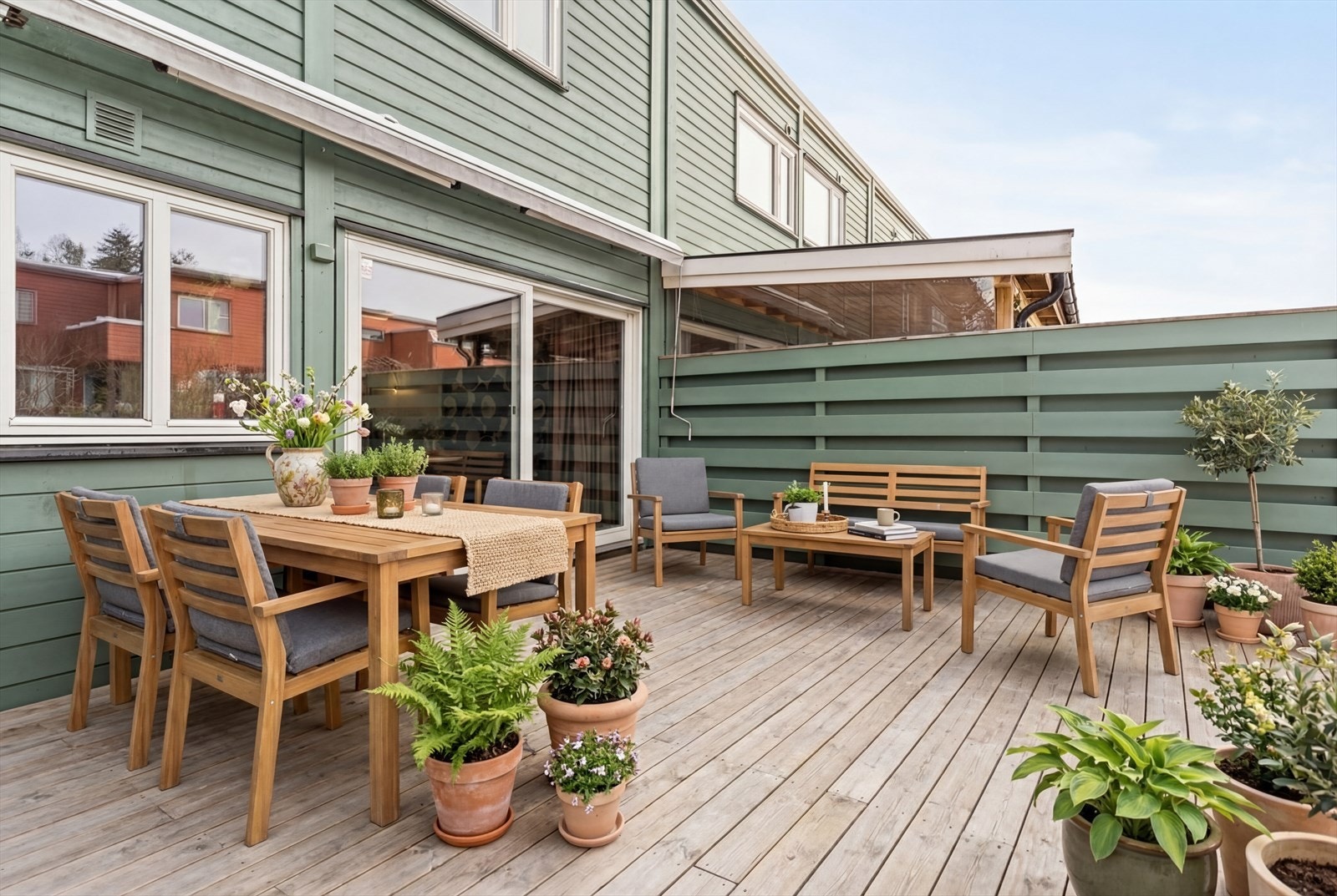 Romslig terrasse med utgang fra stue/kjøkken. Hage i tilknytning til terrassen. Galleribilde