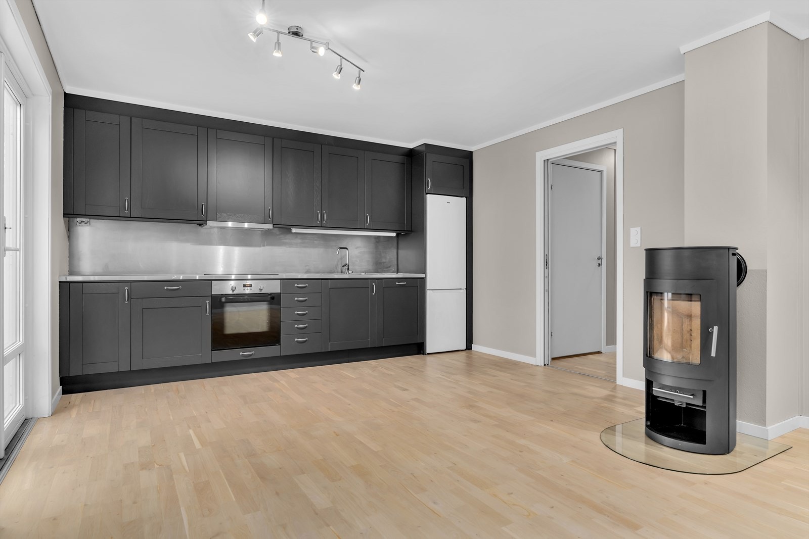 Kjøkkenet har en praktisk innredning med glatte fronter og laminat benkeplate. Galleribilde