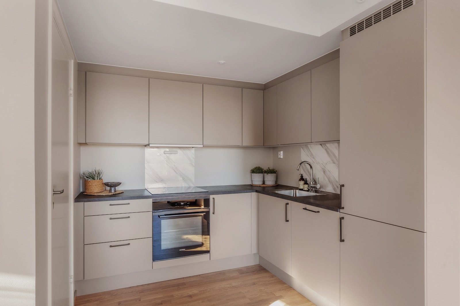 Integrerte hvitevarer som induksjonsovn med platetopp, kjøl/frys og oppvaskmaskin. Det er avtrekk fra ventilator via balansert ventilasjonsanlegg. Galleribilde