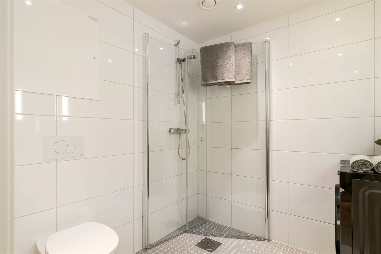 Det stilrene badet på 4m² har helflisede overflater, og varmekabler i gulv som gir en varm og behagelig følelse. Galleribilde