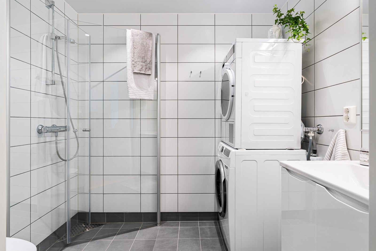 Flislagt bad med stilrene fargevalg. Videre er det romslig baderomsinnredning med servantskap, toalett, dusjarmatur med dusjvegger og behagelig varme i gulv. Galleribilde