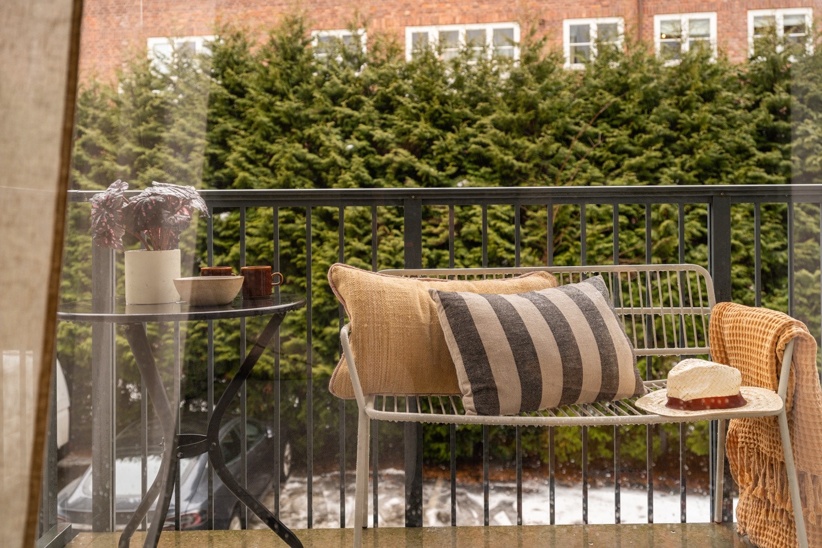 Stuen har store vinduer som slipper inn rikelig med naturlig lys, samtidig som en stor hekk hindrer innsyn. Galleribilde