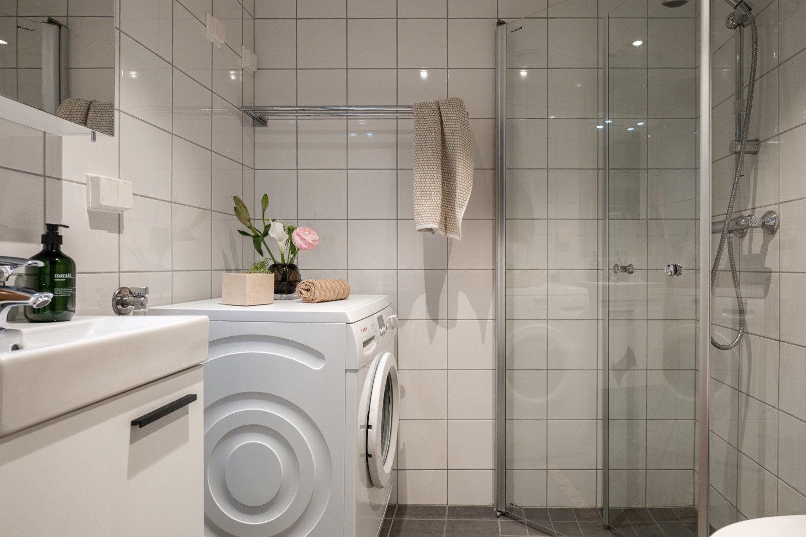 Leiligheten har et lyst og moderne baderom fra 2015. Baderommet har grå fliser på gulv, elektriske varmekabler, lyse fliser på veggene og mekanisk avtrekk. Galleribilde