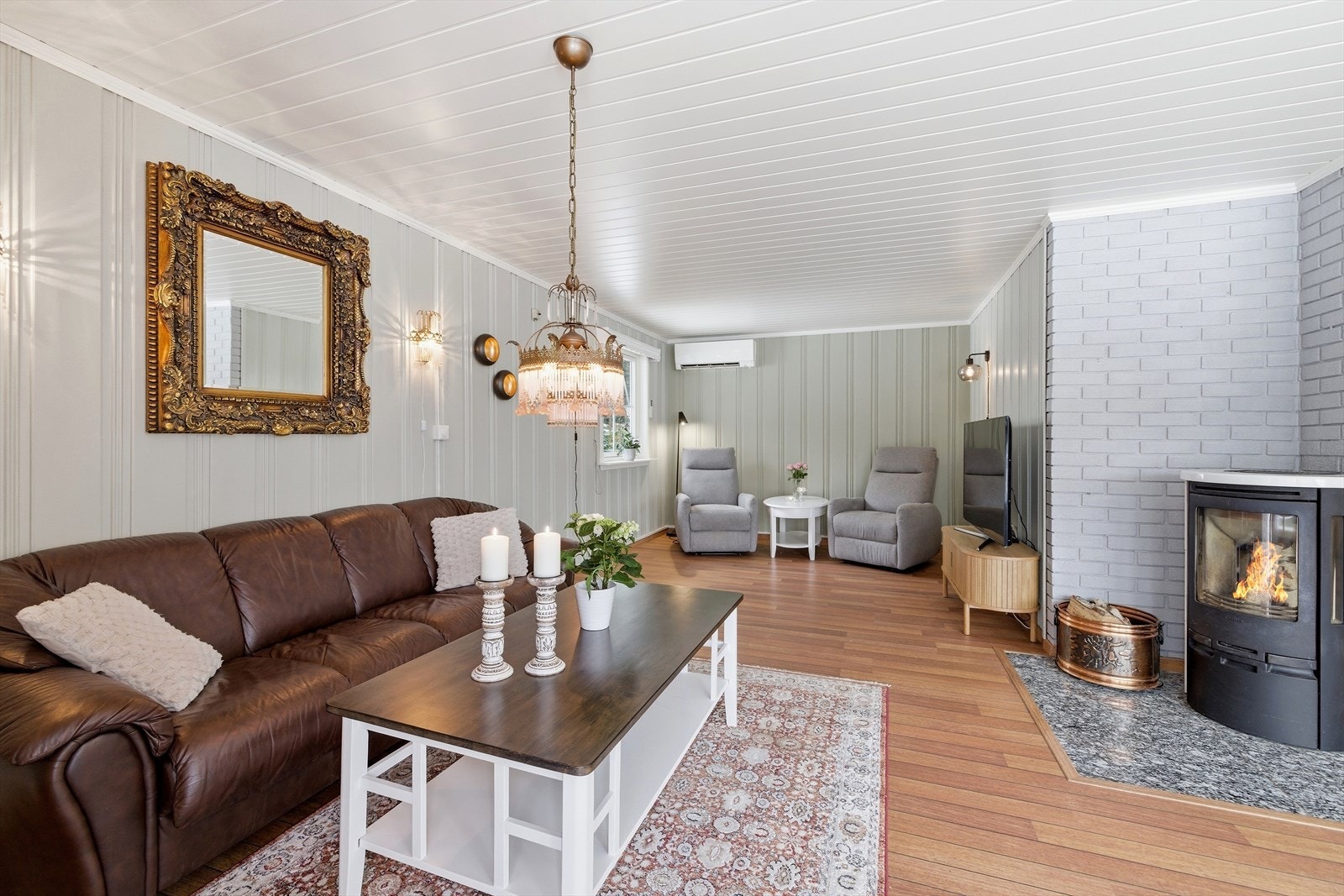 Stuen i hovedetasjen har en hyggelig vedovn for ekstra varme og en luft-til-luft varmepumpe. Galleribilde