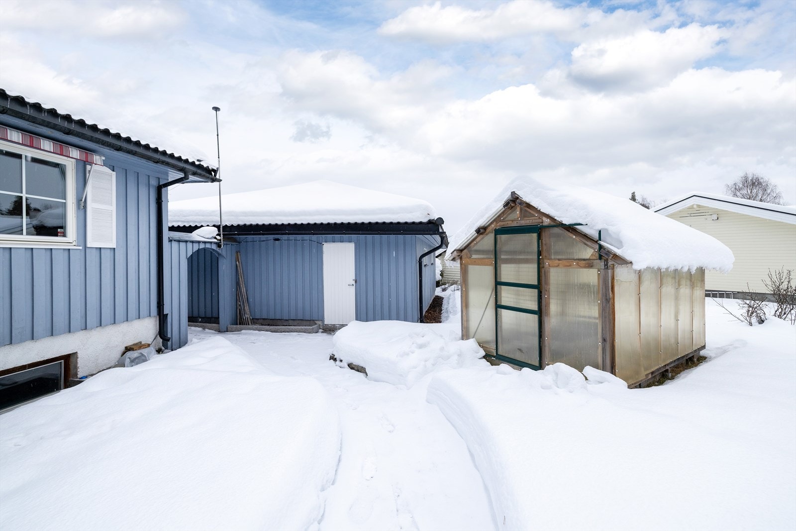 Eiendommen ligger i et plant og pent opparbeidet terreng med asfaltert gårdsplass og beplantning. Galleribilde