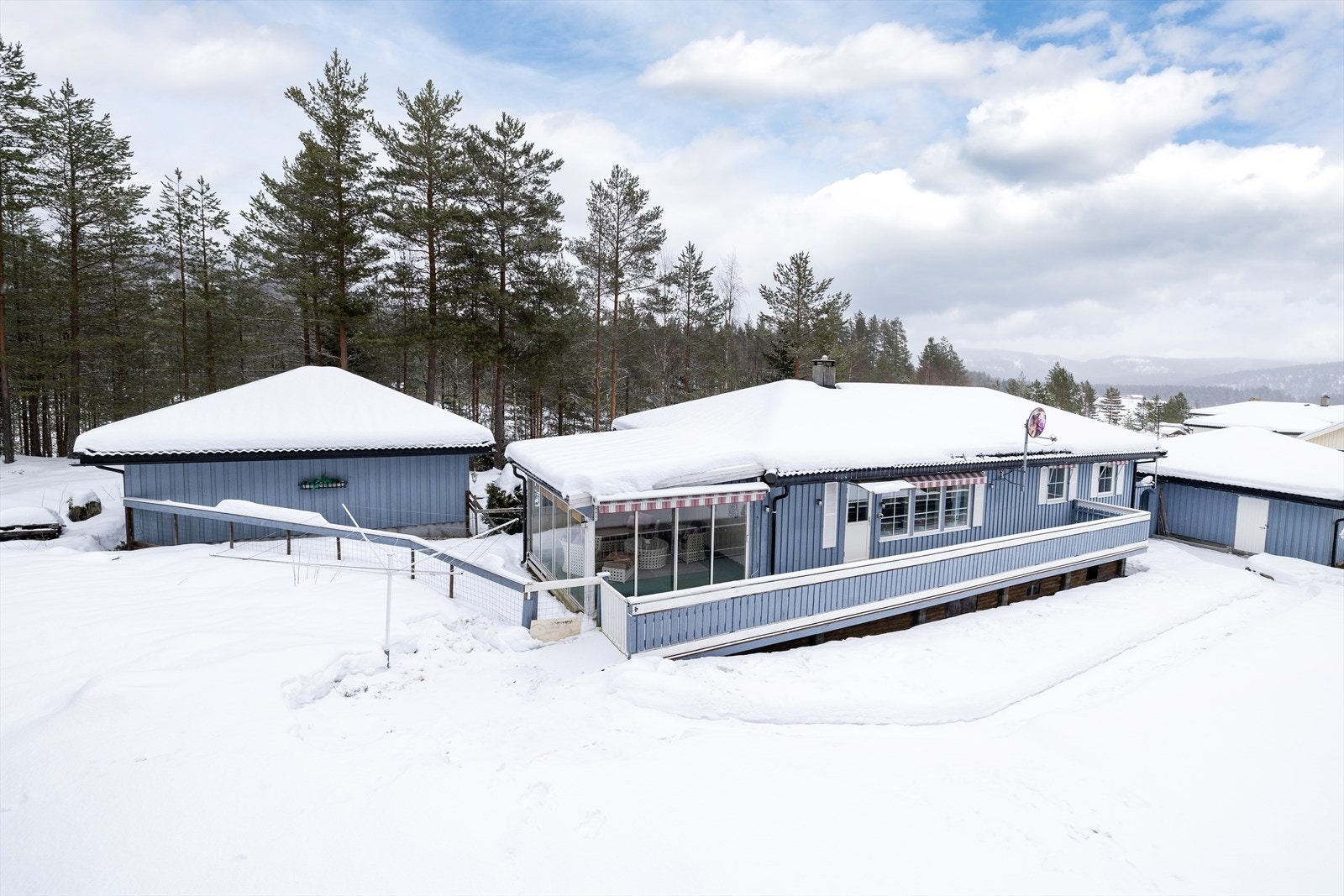 Oversikt over eiendommen som inkluderer enebolig og to frittstående garasjebygg. Galleribilde