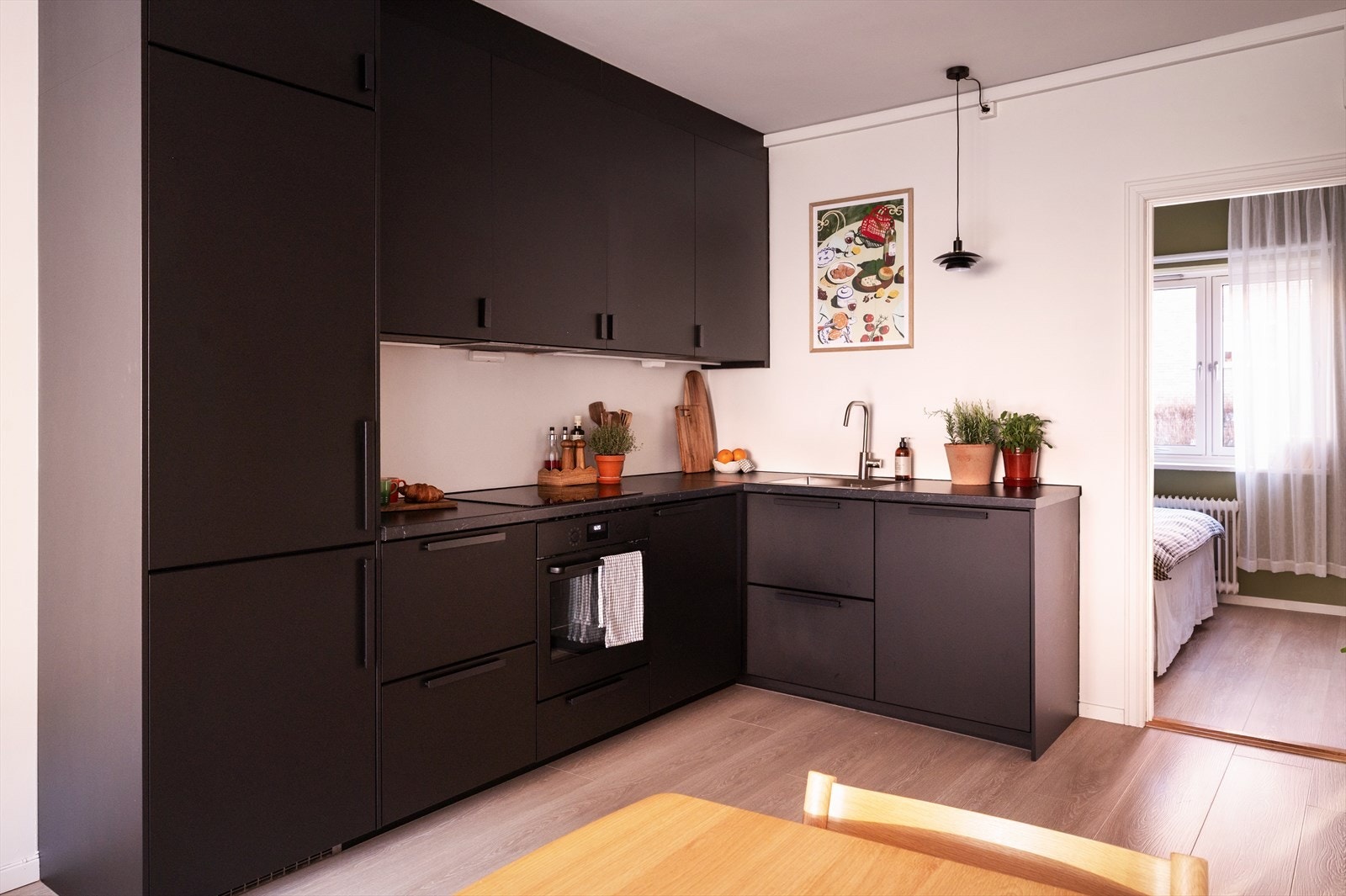 Stilrent og moderne kjøkken med mørke, glatte fronter og rikelig med skap- og benkeplass. Galleribilde