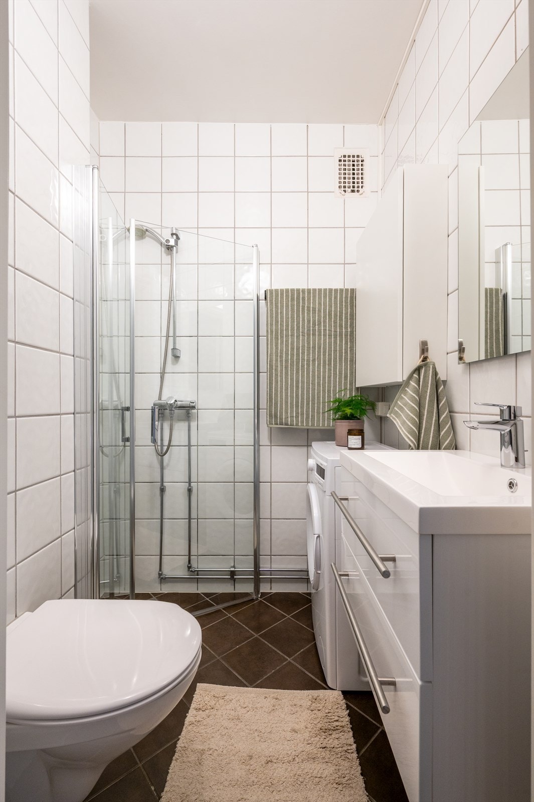 Badet er videre utstyrt med vegghengt toalett og dusjhjørne med svingbare glassdører. Galleribilde