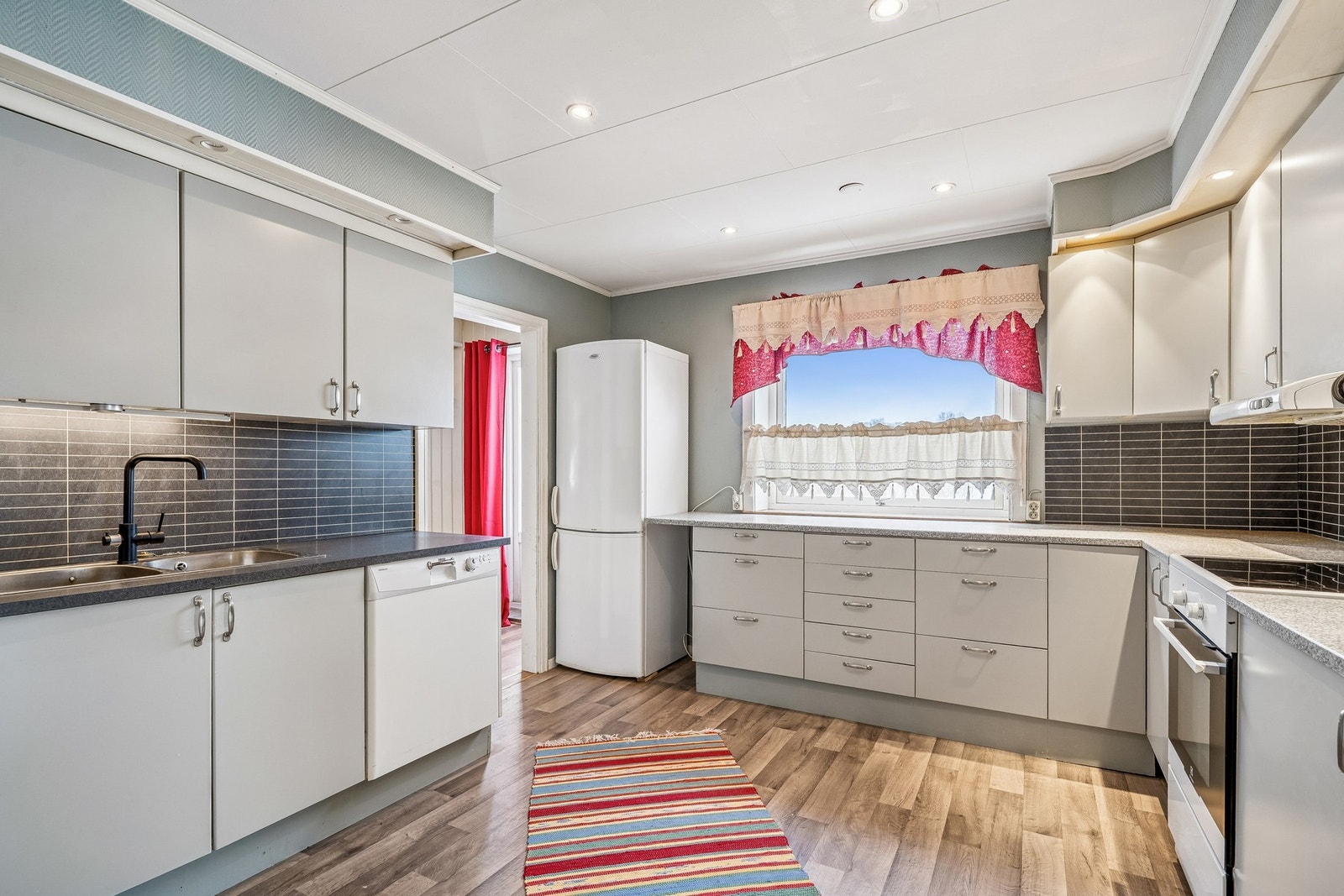 Romslig kjøkken med glatte fronter og laminat benkeplate. Galleribilde