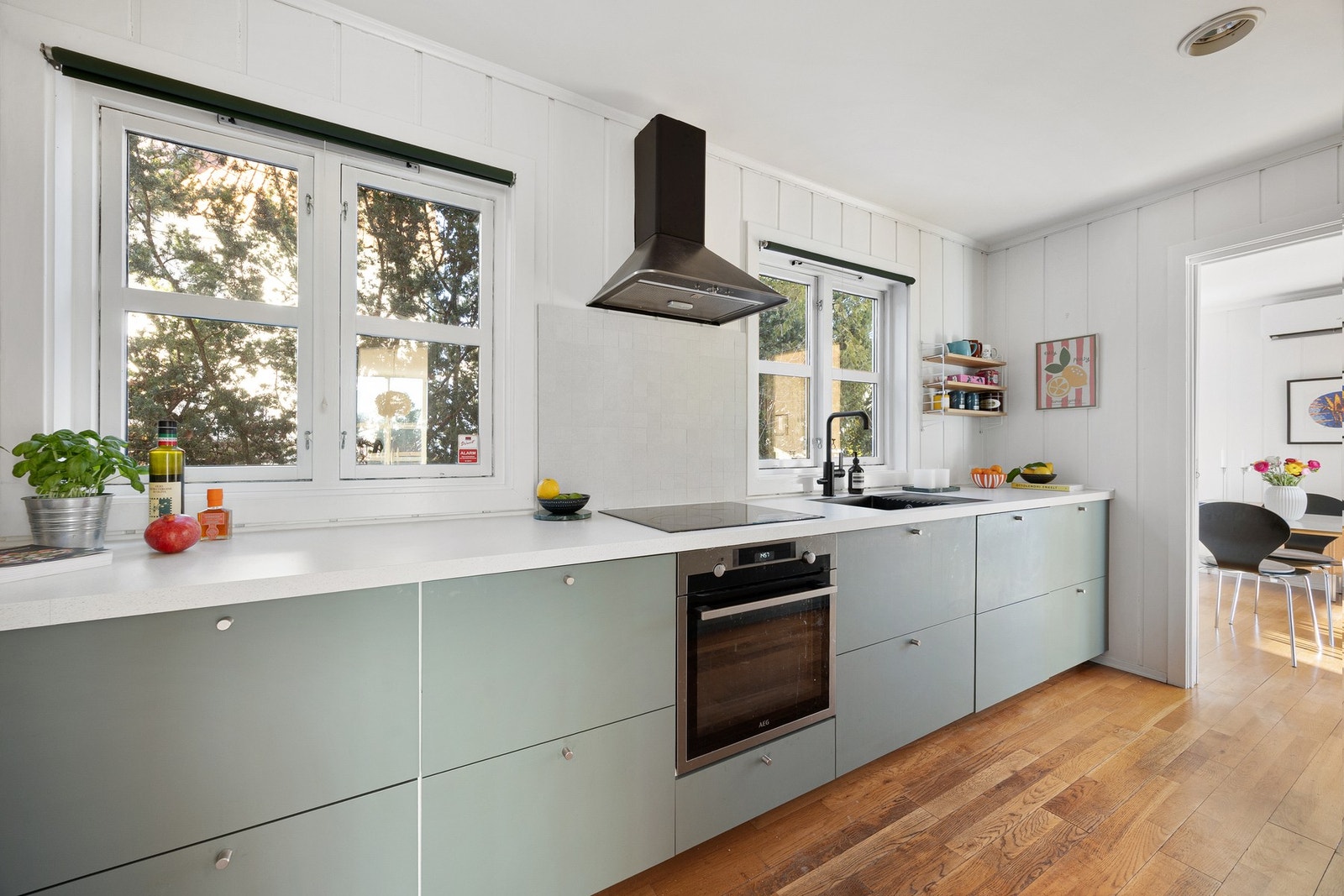 Kjøkkeninnredningen har grønne, glatte fronter og er utstyrt med helintegrerte hvitevarer Galleribilde